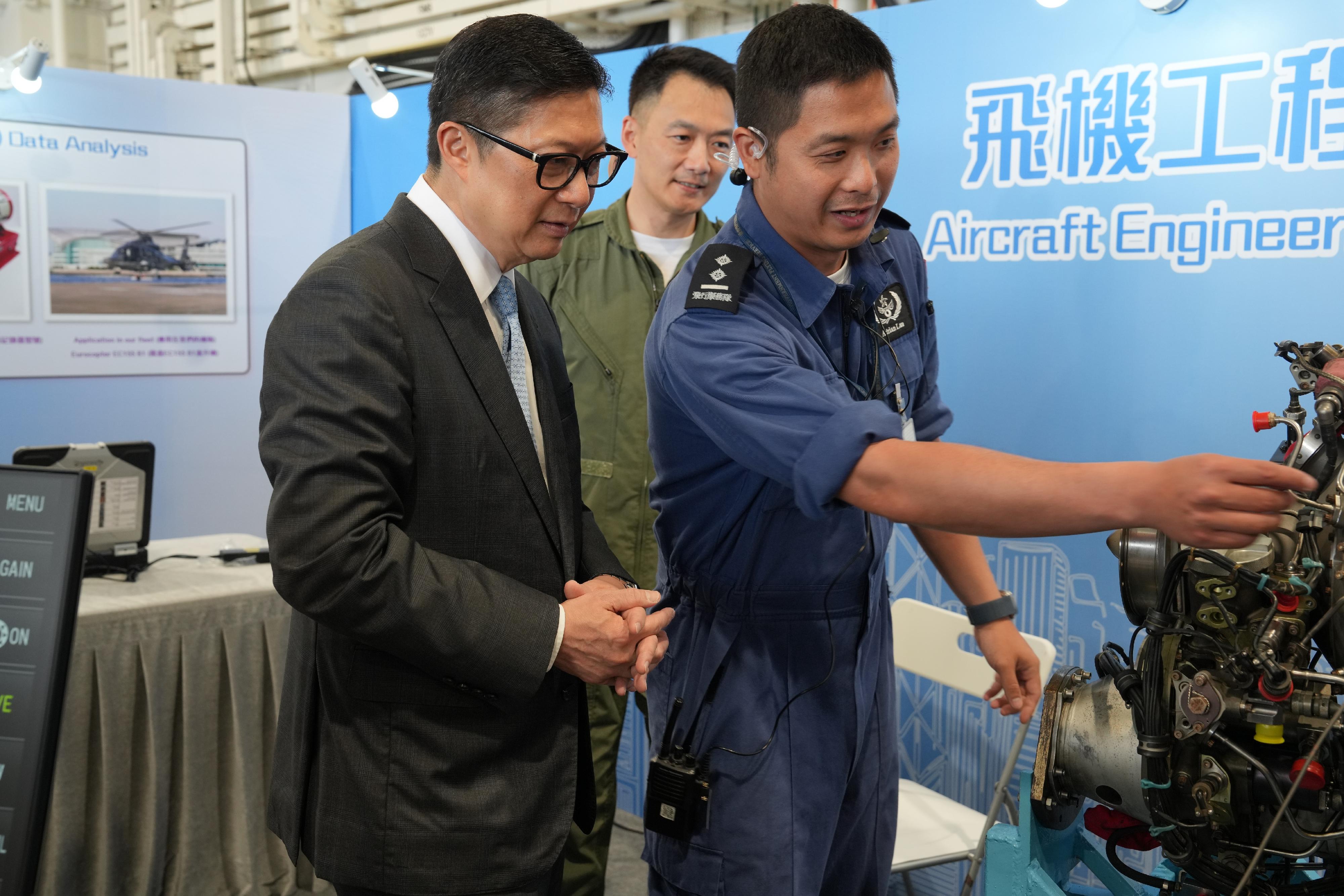 To promote the National Security Education Day, the Government Flying Service (GFS) held an open day today (March 29) at the GFS Kai Tak Division. Photo shows the Secretary for Security, Mr Tang Ping-keung (left), briefed by a GFS officer on aircraft engine. 
