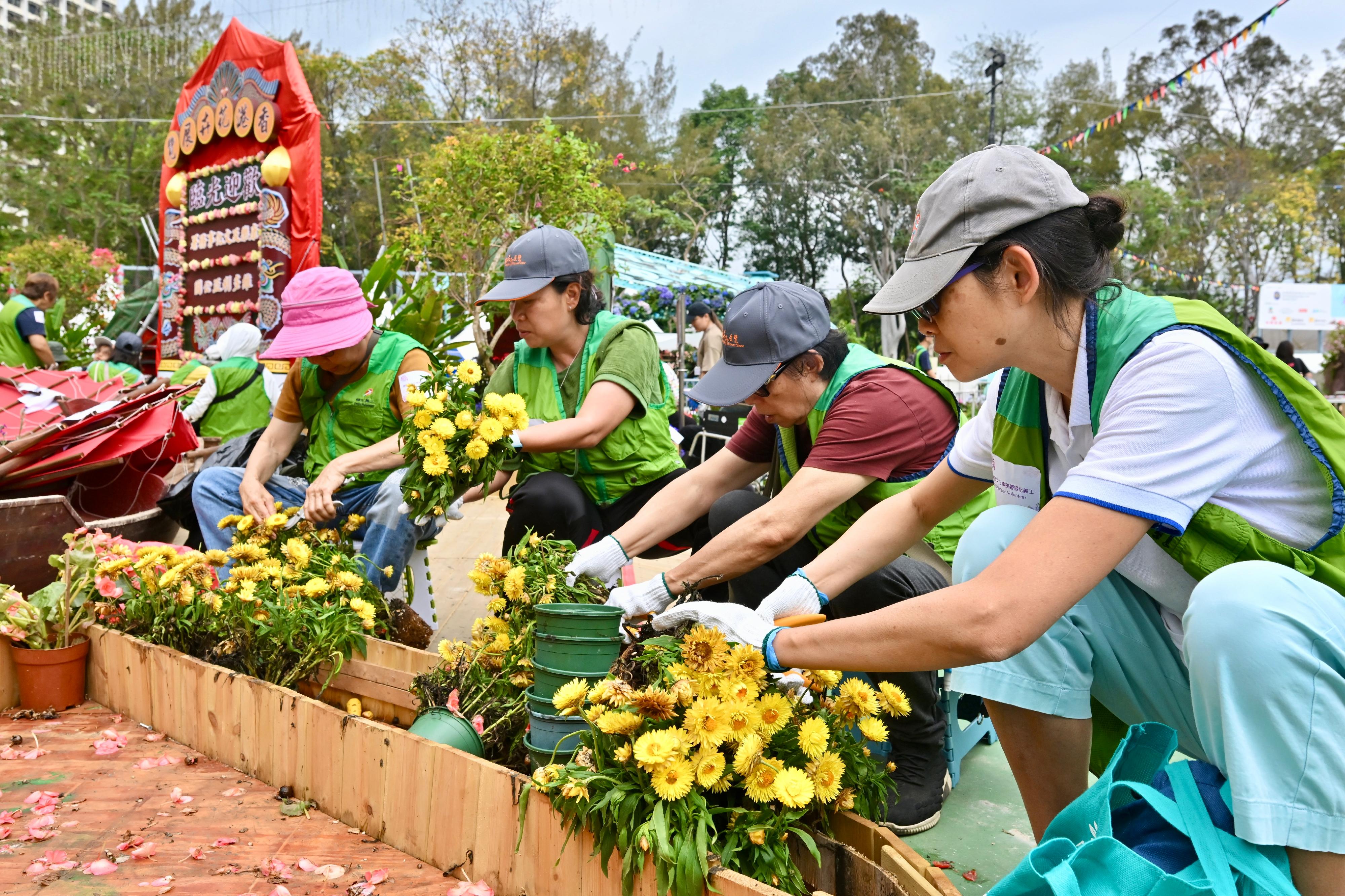The Leisure and Cultural Services Department is once again holding a Green Recycling Day (GRD) upon the conclusion of this year's Hong Kong Flower Show. The GRD activities were held today (March 30) and will continue tomorrow (March 31) at Victoria Park to reinforce green measures and reduce waste. Photo shows volunteers helping classify and collect flowers at the showground.


