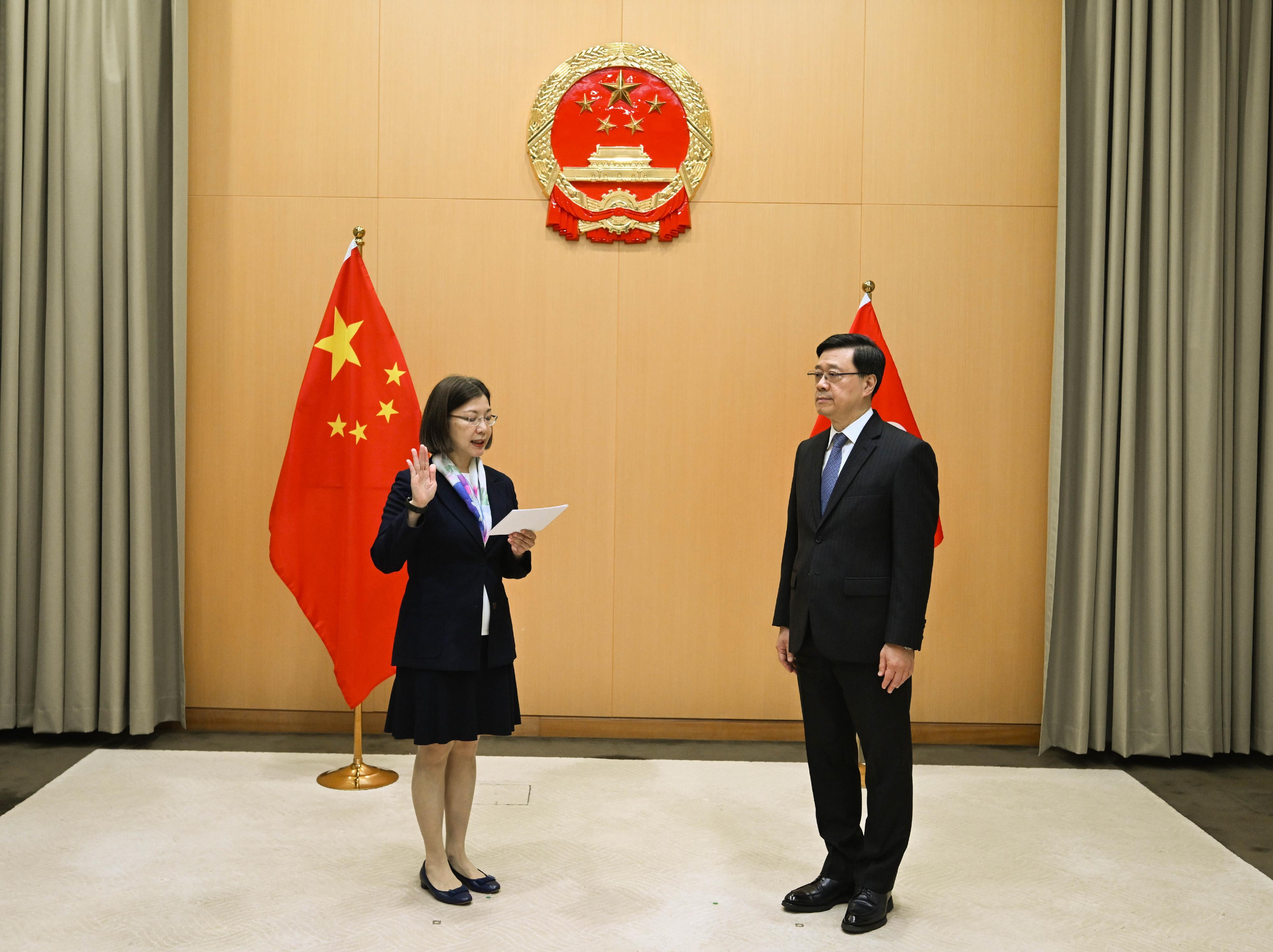 The new Secretary for Constitutional and Mainland Affairs, Miss Janice Tse Siu-wa (left), takes the oath of office, witnessed by the Chief Executive, Mr John Lee (right), today (March 30).