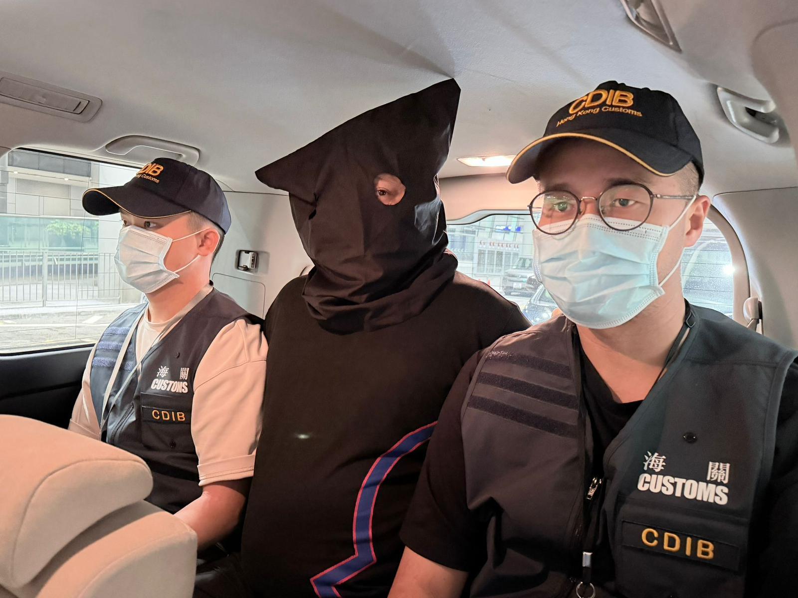 香港海關在香港國際機場偵破三宗行李藏毒的販毒案件，共檢獲約二十二公斤懷疑氯胺酮、約二十一公斤懷疑大麻花、約九點五克無煙煙草、一支另類吸煙產品和兩粒電子煙彈，估計市值共約一千三百萬元，並拘捕三名男子。圖示首宗案件中的被捕人士（中）。