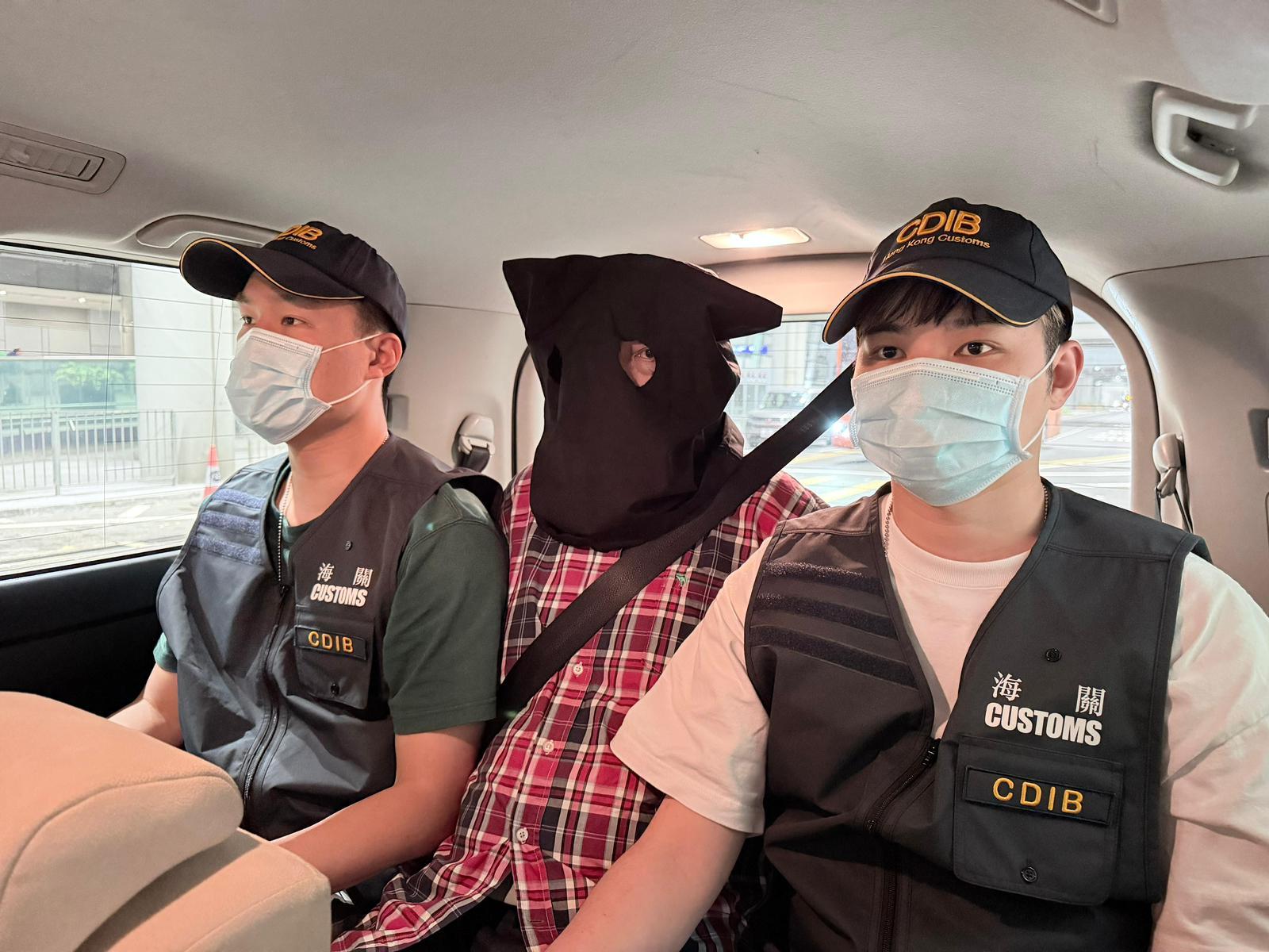 香港海關在香港國際機場偵破三宗行李藏毒的販毒案件，共檢獲約二十二公斤懷疑氯胺酮、約二十一公斤懷疑大麻花、約九點五克無煙煙草、一支另類吸煙產品和兩粒電子煙彈，估計市值共約一千三百萬元，並拘捕三名男子。圖示第二宗案件中的被捕人士（中）。