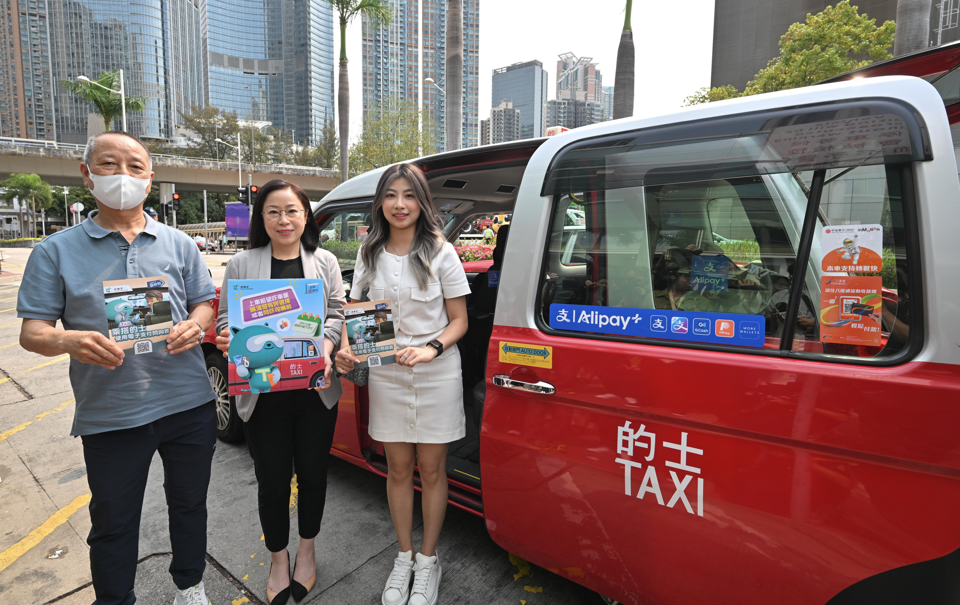 The Commissioner for Transport, Miss Winnie Tse, today (April 1) visited a taxi drop-off point in Tsuen Wan to observe the implementation of the new requirement for taxi drivers to provide electronic payment means on the first day. She was pleased to note that the overall operation was generally smooth. Photo shows Miss Tse (centre), a driver and a passenger.