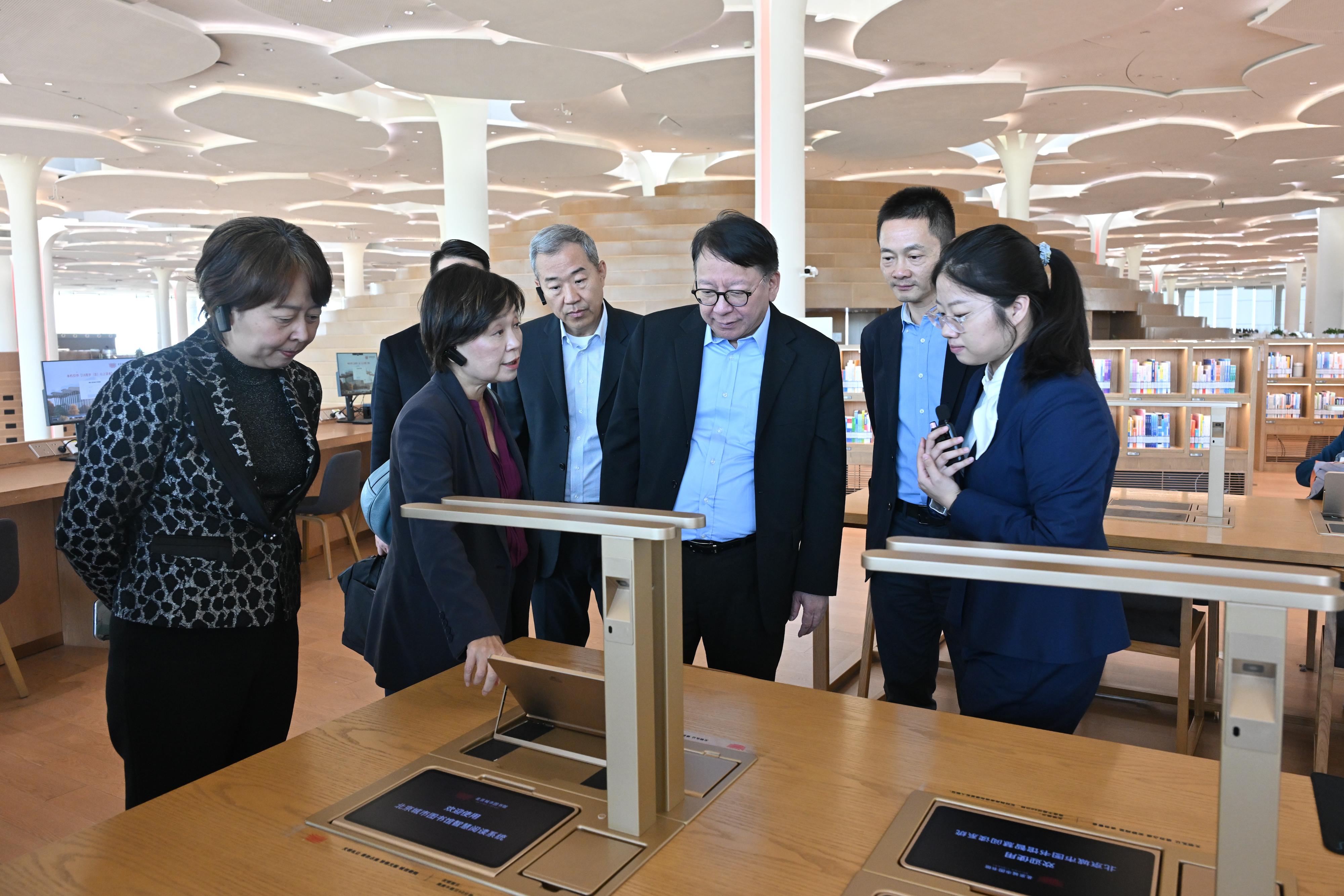 The Chief Secretary for Administration, Mr Chan Kwok-ki, today (April 1) led the delegation of the Working Group on Planning and Construction of the University Town under the Committee on Development of the Northern Metropolis to continue its visit to the Beijing Municipal Administrative Center and Xiong'an New Area in Hebei. Photo shows Mr Chan (third right), the Secretary for Education, Dr Choi Yuk-lin (second left), and the delegation, accompanied by  the Director of Bureau IV of the Hong Kong and Macao Work Office of the Communist Party of China Central Committee and the Hong Kong and Macao Affairs Office of the State Council, Mr Chen Wei (second right), visiting the Beijing Library of the Beijing Municipal Administrative Center.