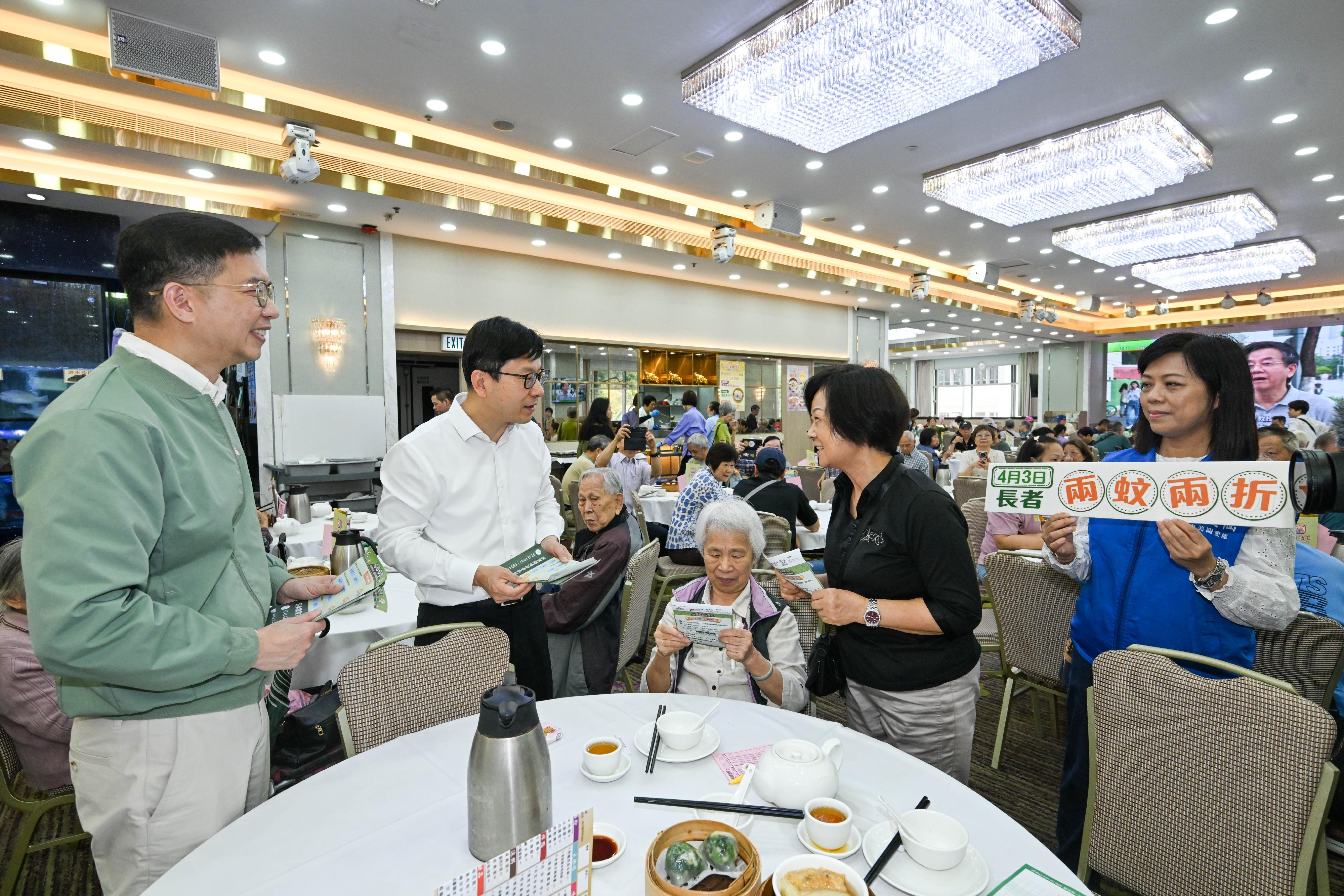 政府長者及合資格殘疾人士公共交通票價優惠計劃（二元優惠計劃）今日（四月三日）起由二元劃一收費調整為「兩蚊兩折」。勞工及福利局局長孫玉菡今日到黃大仙及調景嶺視察「兩蚊兩折」首日實施情況。圖示孫玉菡（左二）在黃大仙一間酒家，向市民介紹二元優惠計劃的收費調整。