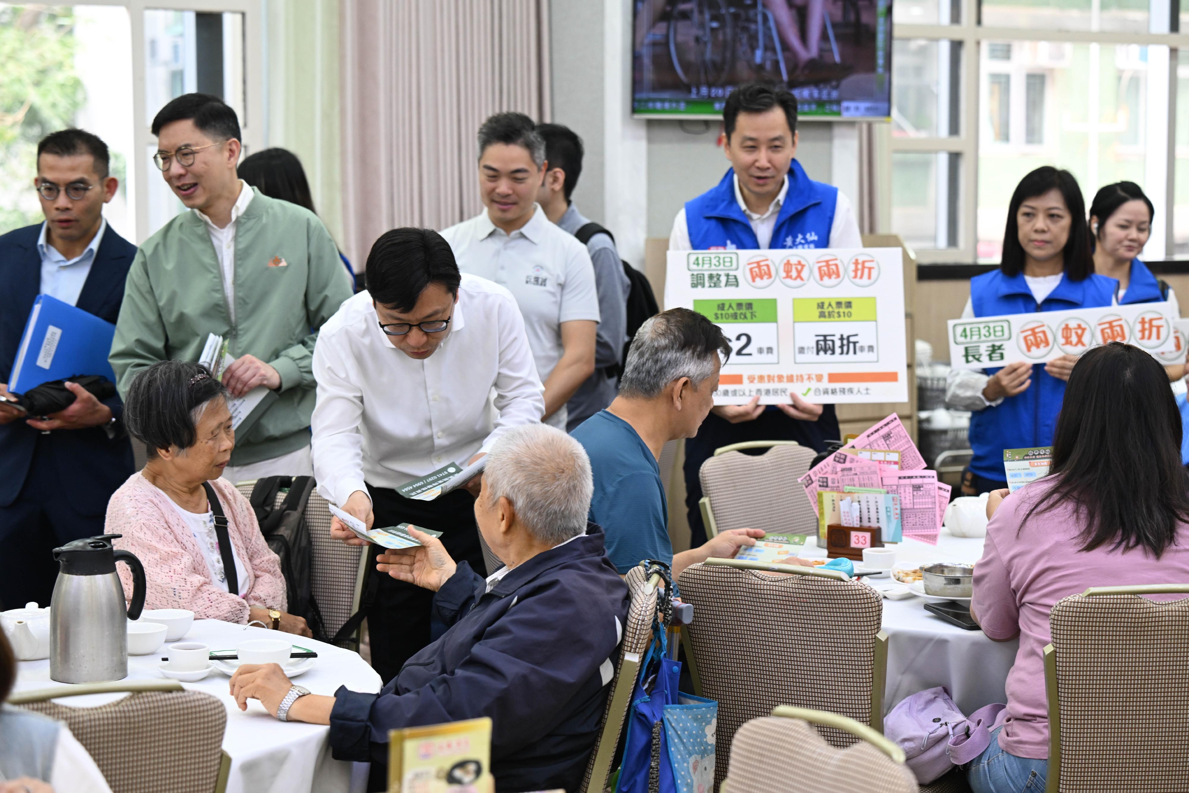 政府長者及合資格殘疾人士公共交通票價優惠計劃（二元優惠計劃）今日（四月三日）起由二元劃一收費調整為「兩蚊兩折」。勞工及福利局局長孫玉菡今日到黃大仙及調景嶺視察「兩蚊兩折」首日實施情況。圖示孫玉菡（前排左二）在黃大仙一間酒家，向市民介紹二元優惠計劃的收費調整。