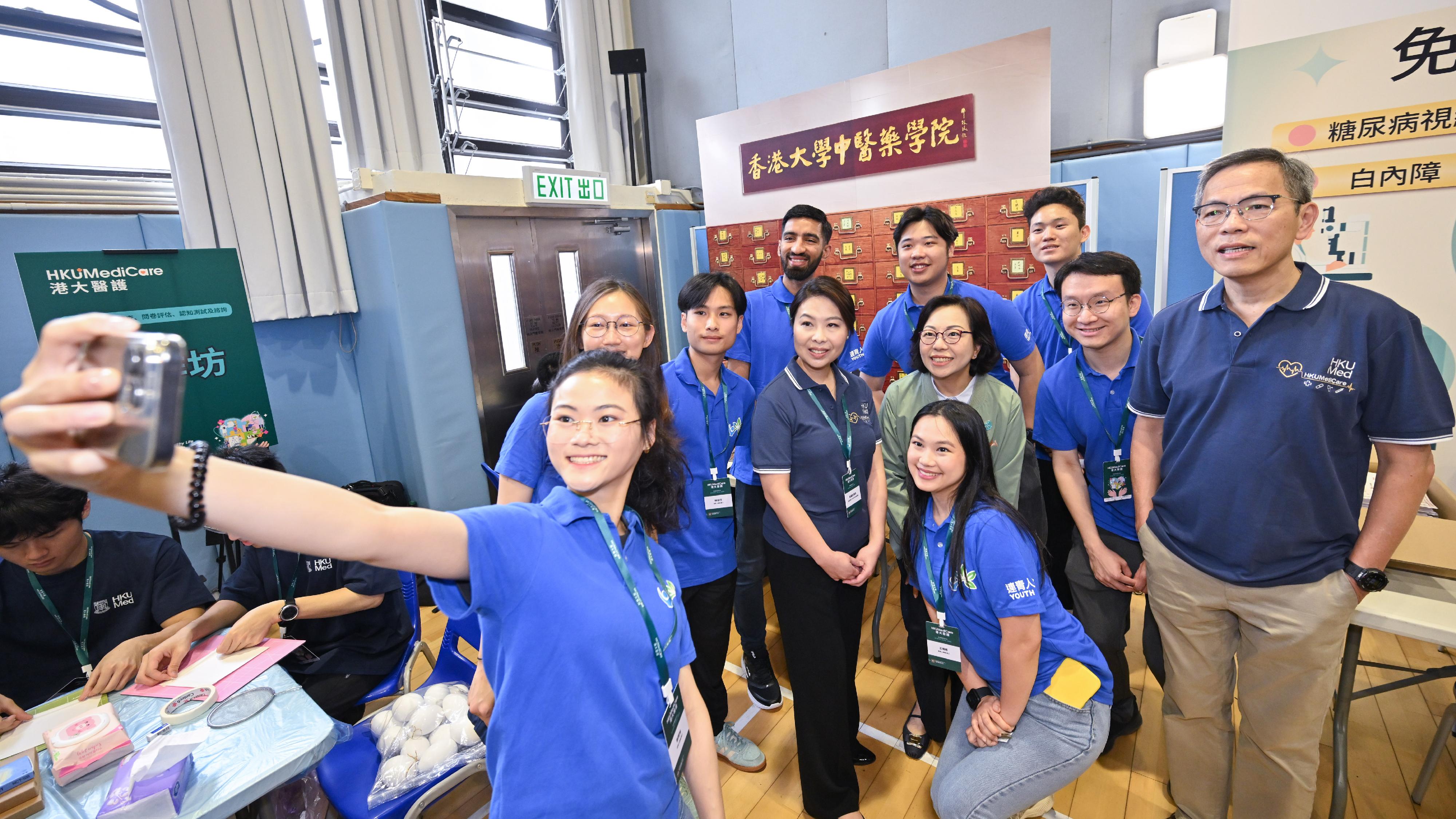 The Home and Youth Affairs Bureau, the District Services & Community Care Teams, and the Li Ka Shing Faculty of Medicine of the University of Hong Kong (HKUMed) held the kick-off ceremony of the "Shape Your Healthy Life: 18 District Health Community Project" and the first district outreach health promotion event at the Sai Ying Pun Community Complex Community Hall today (April 7). Photo shows the Secretary for Home and Youth Affairs, Miss Alice Mak (second row, second right), and the Dean ofthe HKUMed, Professor Lau Chak-sing (first right), with the volunteers of the "Youth Link".