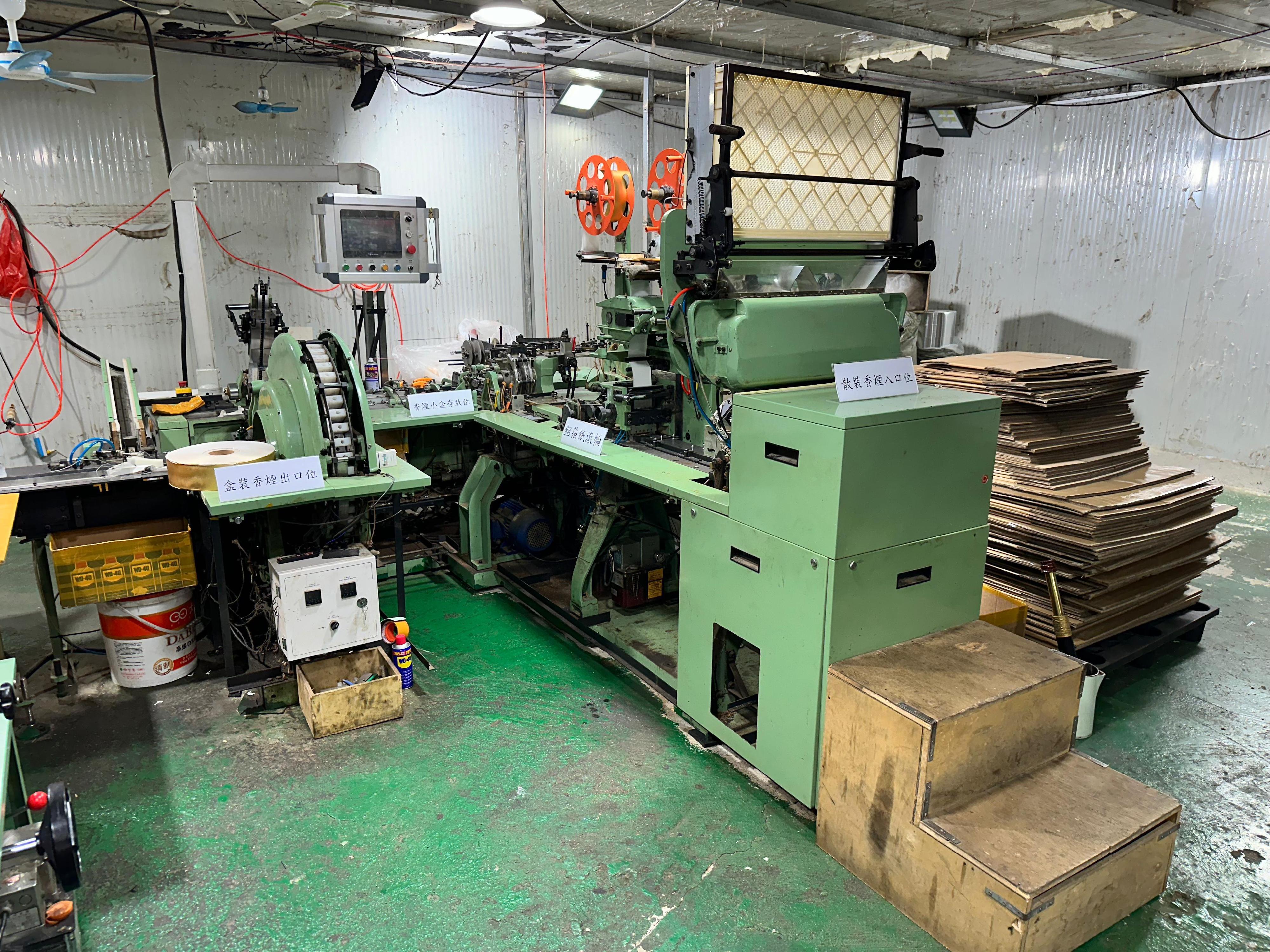 Hong Kong Customs shut down an underground cigarette factory in Fanling yesterday (April 9), and seized about 31.92 tons of suspected duty-not-paid manufactured tobacco and 1.23 million sticks of suspected illicit cigarette. The total estimated market value of all seizure was about $220 million, while the duty potential was about $130 million. Six persons suspected to be connected with the case were arrested. Photo shows the machines for producing and packaging illicit cigarettes seized in the metal hut.