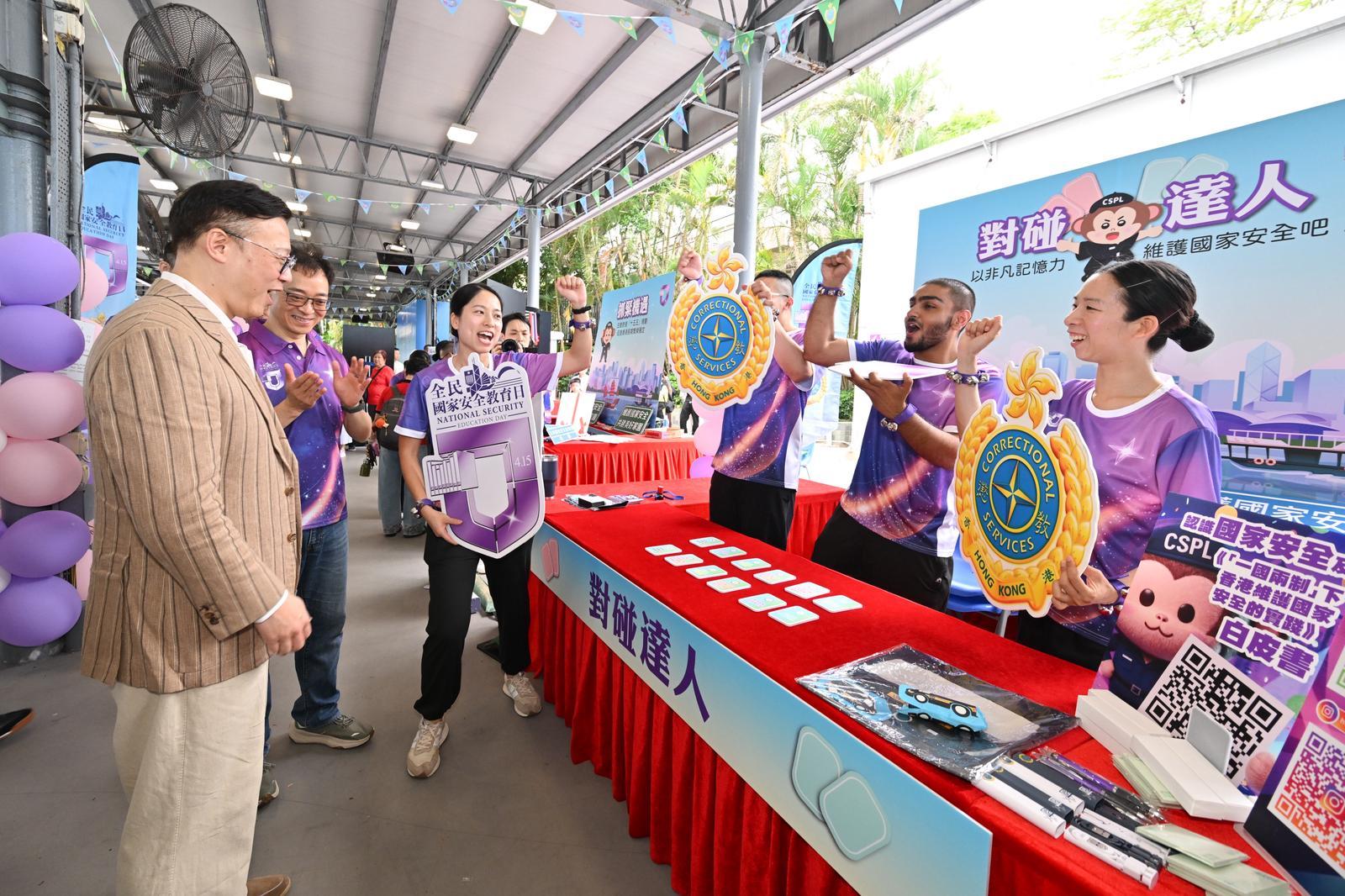 To support the 11th National Security Education Day on April 15 this year, the Correctional Services Department held an open day at the Hong Kong Correctional Services Museum and the Community Education Experience Centre today (April 11). Photo shows the Deputy Secretary for Justice, Dr Cheung Kwok-kwan (left), accompanied by the Commissioner of Correctional Services, Mr Wong Kwok-hing (second left), participating in a booth game centred on the white paper on "Hong Kong: Safeguarding China's National Security Under the Framework of One Country, Two Systems".