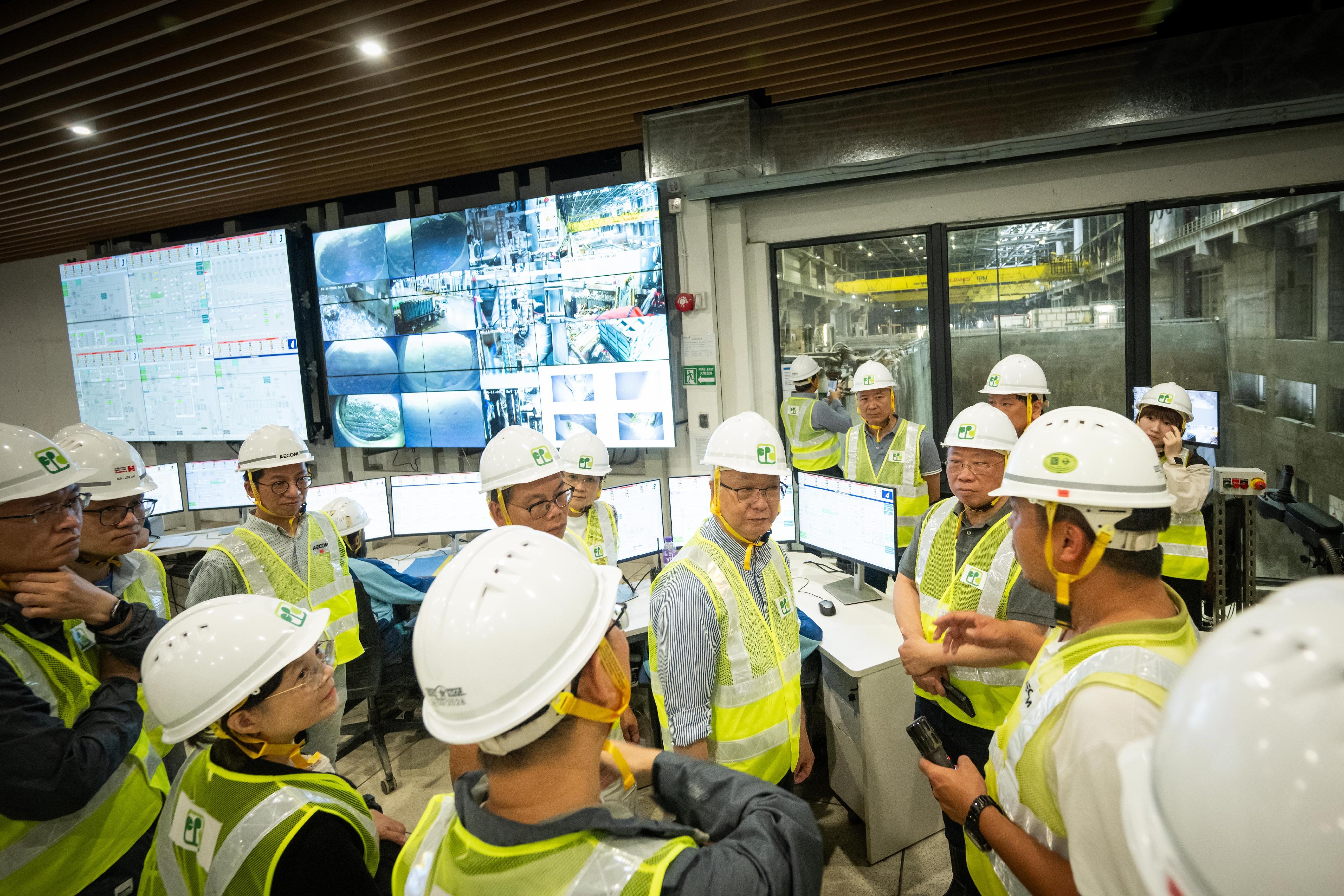 The Secretary for Environment and Ecology, Mr Tse Chin-wan, today (April 11) and several members of the Legislative Council (LegCo) inspected Hong Kong's first modern waste-to-energy facility located on an artificial island off Shek Kwu Chau for treating municipal solid waste - Integrated Waste Management Facilities Phase I (I·PARK1). Photo shows Mr Tse (centre); the Under Secretary for Environment and Ecology, Miss Diane Wong (front row, second left) and LegCo members observing the waste treatment processes in the central control room.
