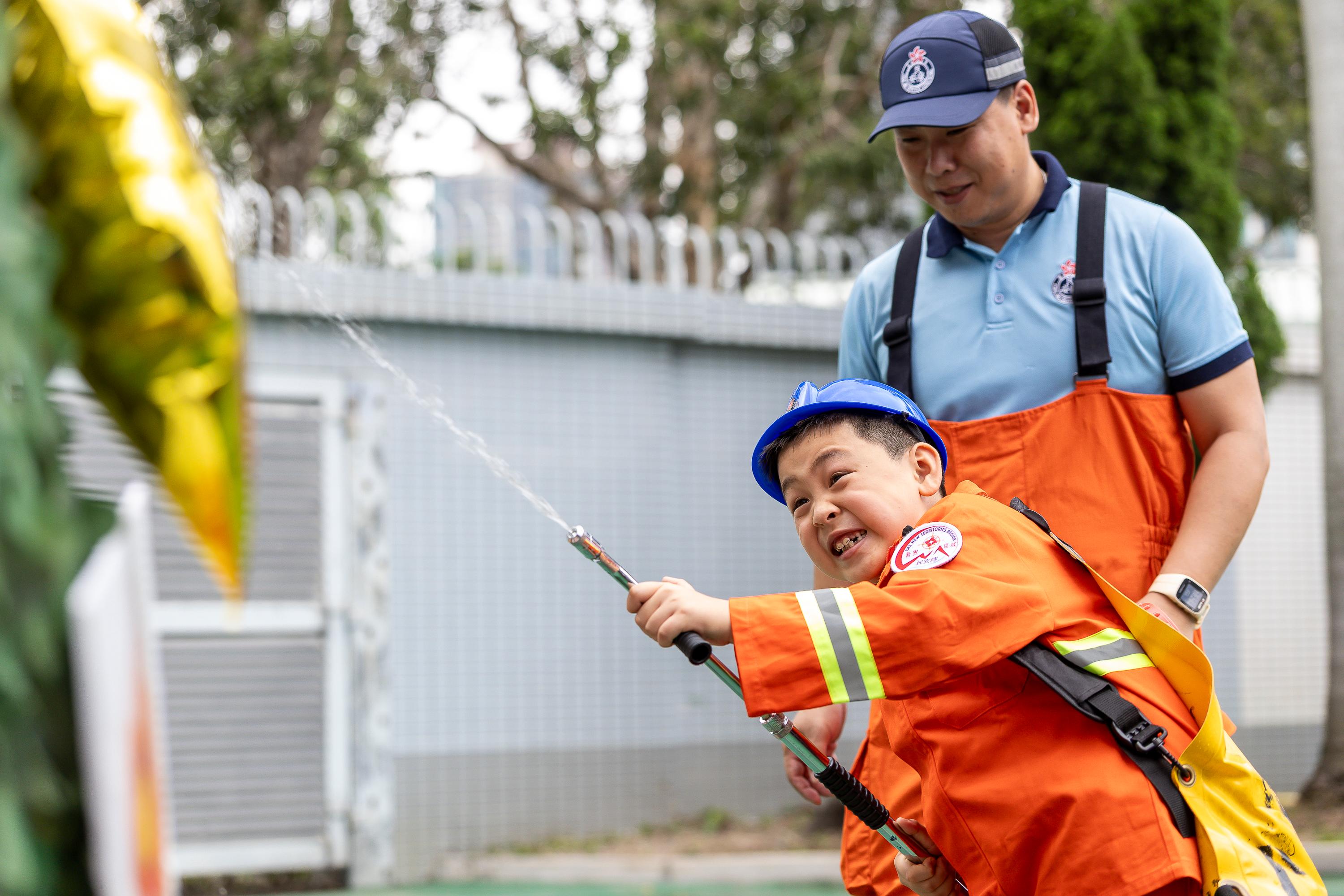The Civil Aid Service held an open day at its headquarters today (April 11) to promote National Security Education Day. Photo shows members of the public taking part in game booths.