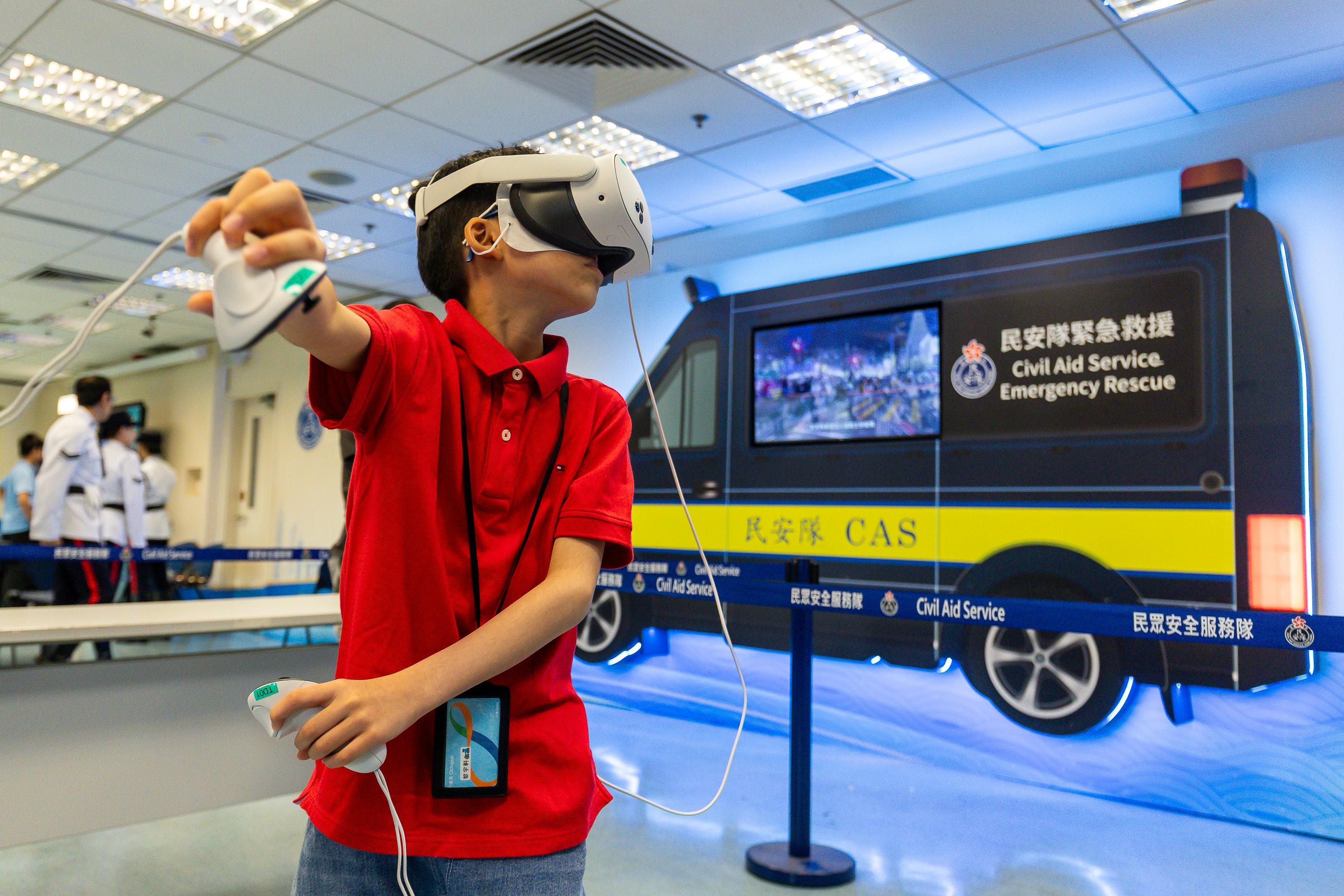 The Civil Aid Service held an open day at its headquarters today (April 11) to promote National Security Education Day. Photo shows members of the public enjoying a virtual reality experience.