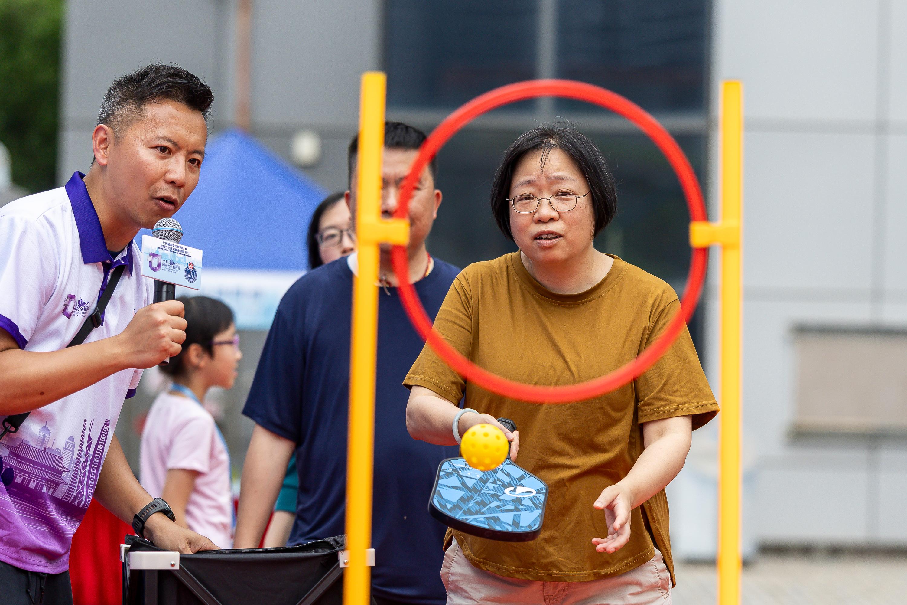 The Civil Aid Service held an open day at its headquarters today (April 11) to promote National Security Education Day. Photo shows members of the public playing a pickleball.