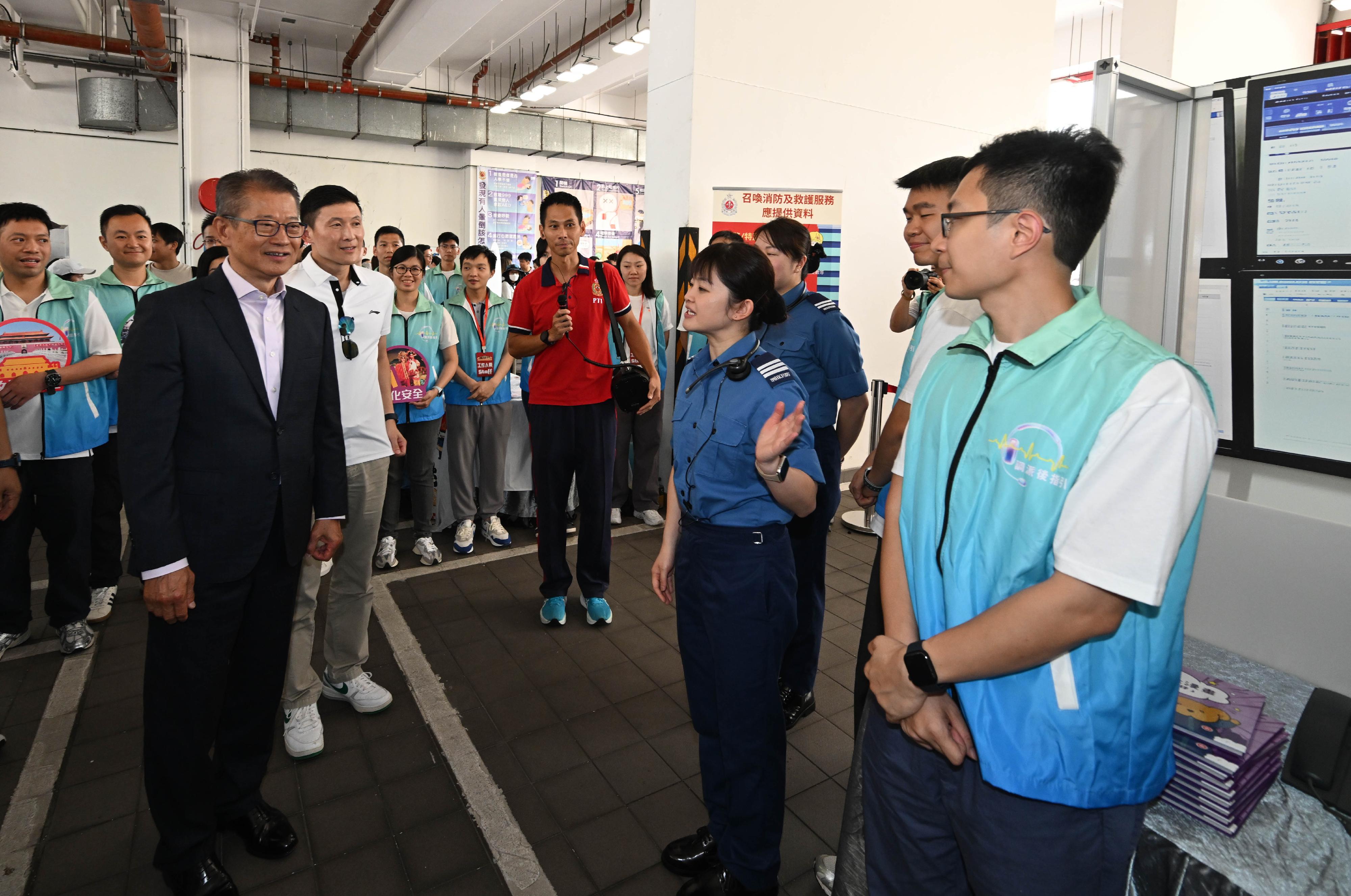 In response to and in support of the 11th National Security Education Day, the Fire Services Department held an open day at the Fire and Ambulance Services Academy in Tseung Kwan O today (April 12). Photo shows the Financial Secretary, Mr Paul Chan (front row, first left), accompanied by the Deputy Director of Fire Services (Operations), Mr Derek Armstrong Chan (front row, second left), receiving a briefing on the latest development of the Fire Services Communications Centre's operation.
