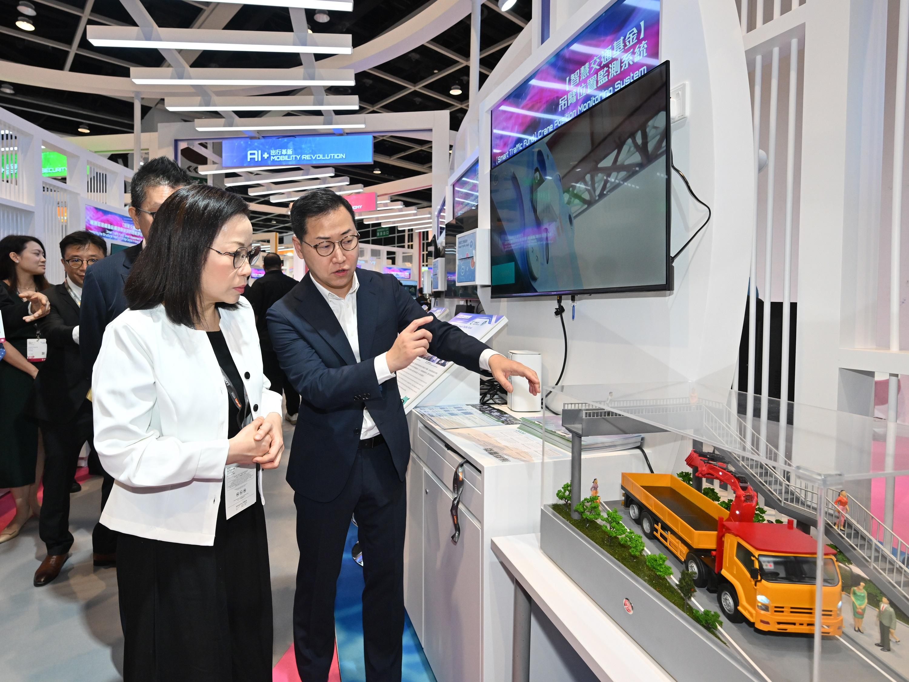 The Commissioner for Transport, Miss Winnie Tse, today (April 13) visited the InnoEX to learn more about the Smart Traffic Fund projects showcased at the Smart Hong Kong Pavilion, and experience the integration of digital technology and artificial intelligence into traffic and transport solutions. Photo shows Miss Tse (left) being briefed on how a monitoring system for crane height and position safeguards driving and road safety.