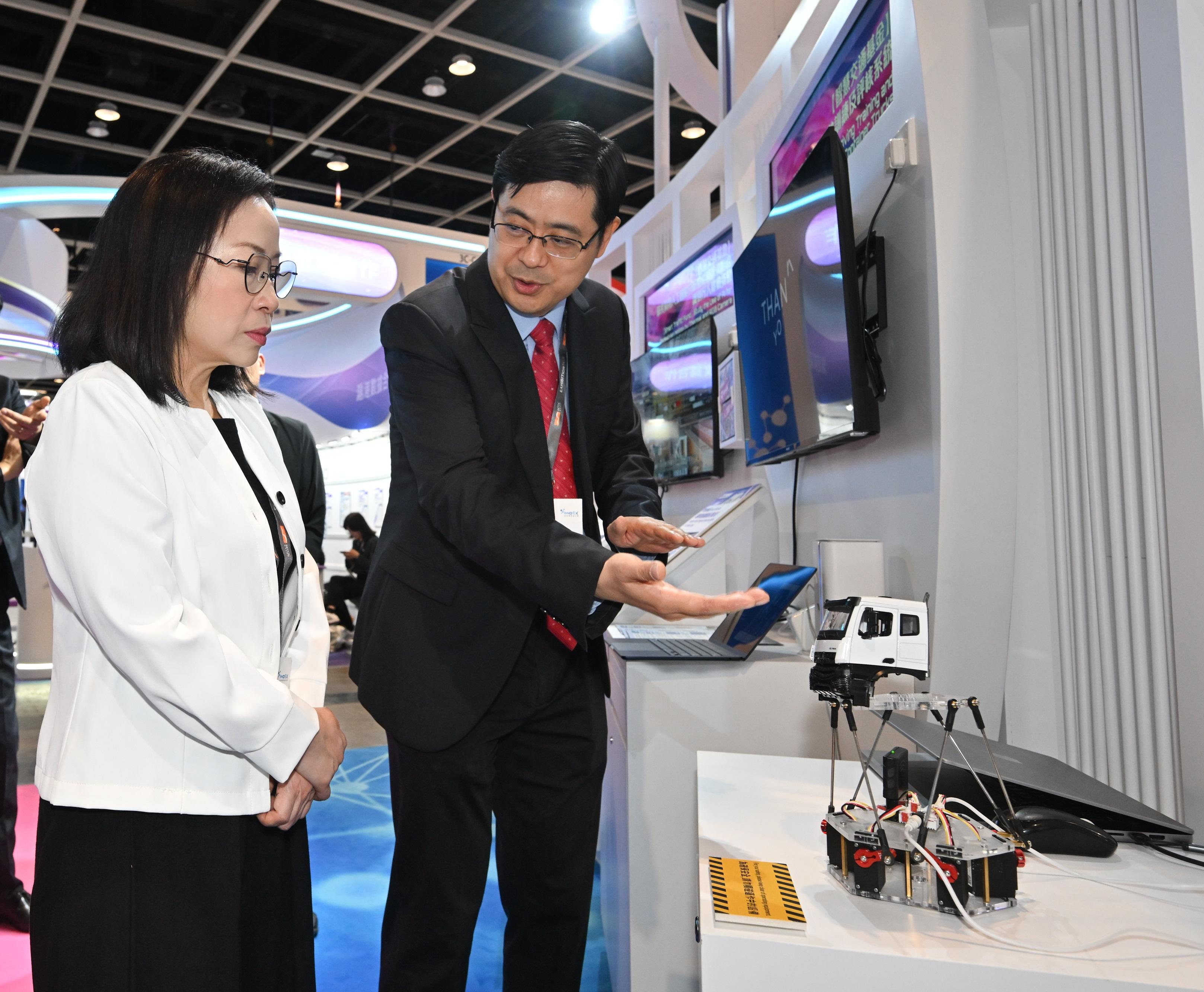 The Commissioner for Transport, Miss Winnie Tse, today (April 13) visited the InnoEX to learn more about the Smart Traffic Fund projects showcased at the Smart Hong Kong Pavilion, and experience the integration of digital technology and artificial intelligence into traffic and transport solutions. Photo shows Miss Tse (left) being briefed on an intelligent driving training system for container trucks providing drivers with realistic simulation for driving training.&nbsp;