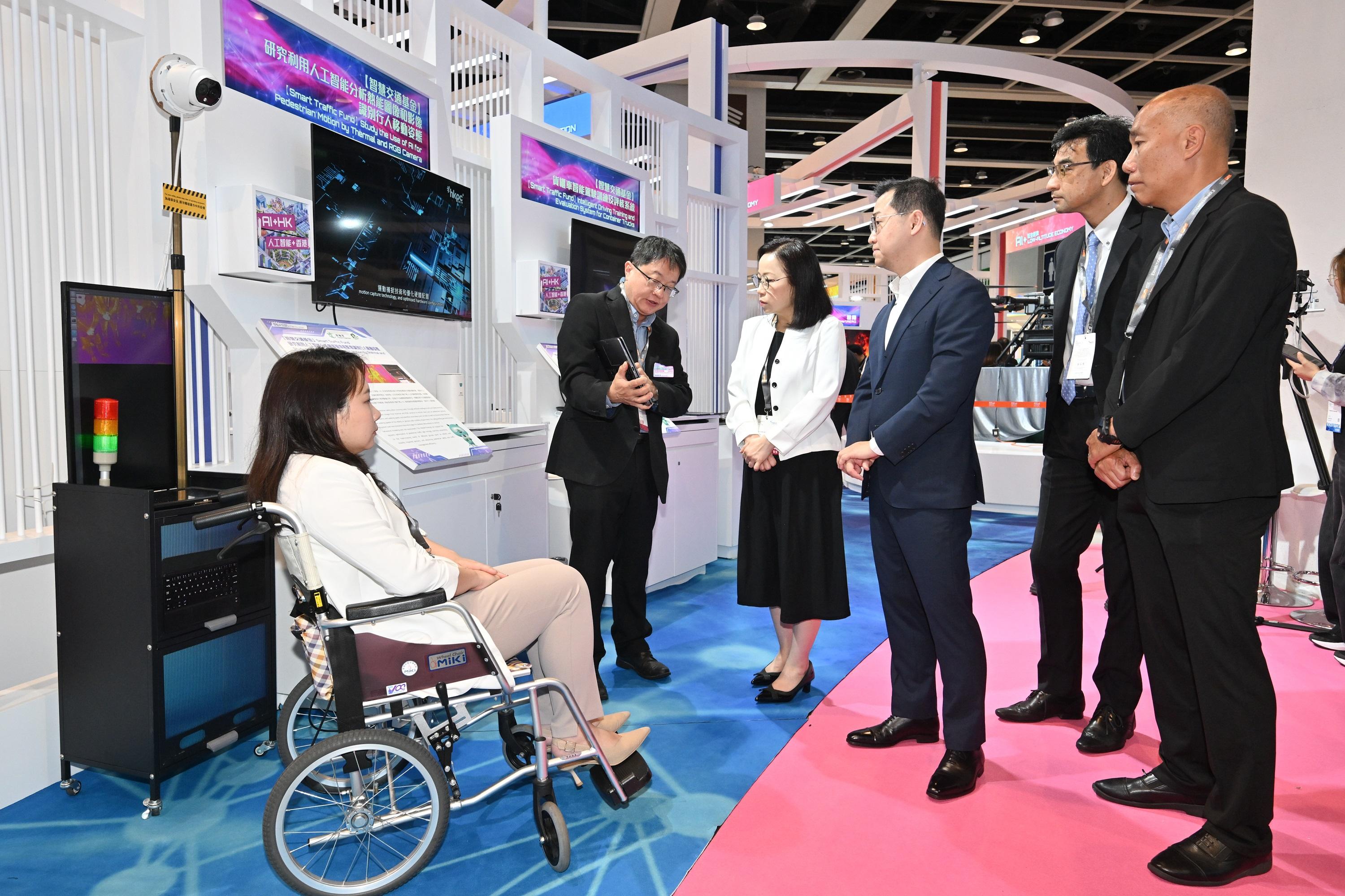 The Commissioner for Transport, Miss Winnie Tse, today (April 13) visited the InnoEX to learn more about the Smart Traffic Fund projects showcased at the Smart Hong Kong Pavilion, and experience the integration of digital technology and artificial intelligence (AI) into traffic and transport solutions. Photo shows Miss Tse (third left) looking at a demonstration of using AI technology to analyse pedestrian (e.g. wheelchair users) motion to support the dynamic optimisation of pedestrian traffic signal timings.