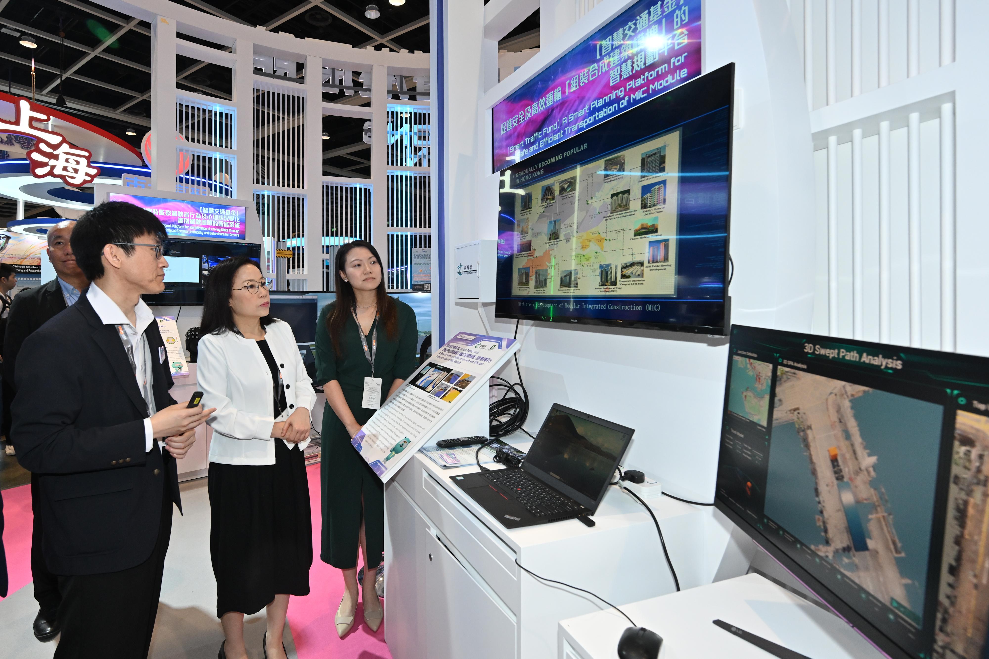 The Commissioner for Transport, Miss Winnie Tse, today (April 13) visited the InnoEX to learn more about the Smart Traffic Fund projects showcased at the Smart Hong Kong Pavilion, and experience the integration of digital technology and artificial intelligence into traffic and transport solutions. Photo shows Miss Tse (centre) learning about a smart route planning platform for transporting modular integrated construction modules and how it enhances transport safety and efficiency.