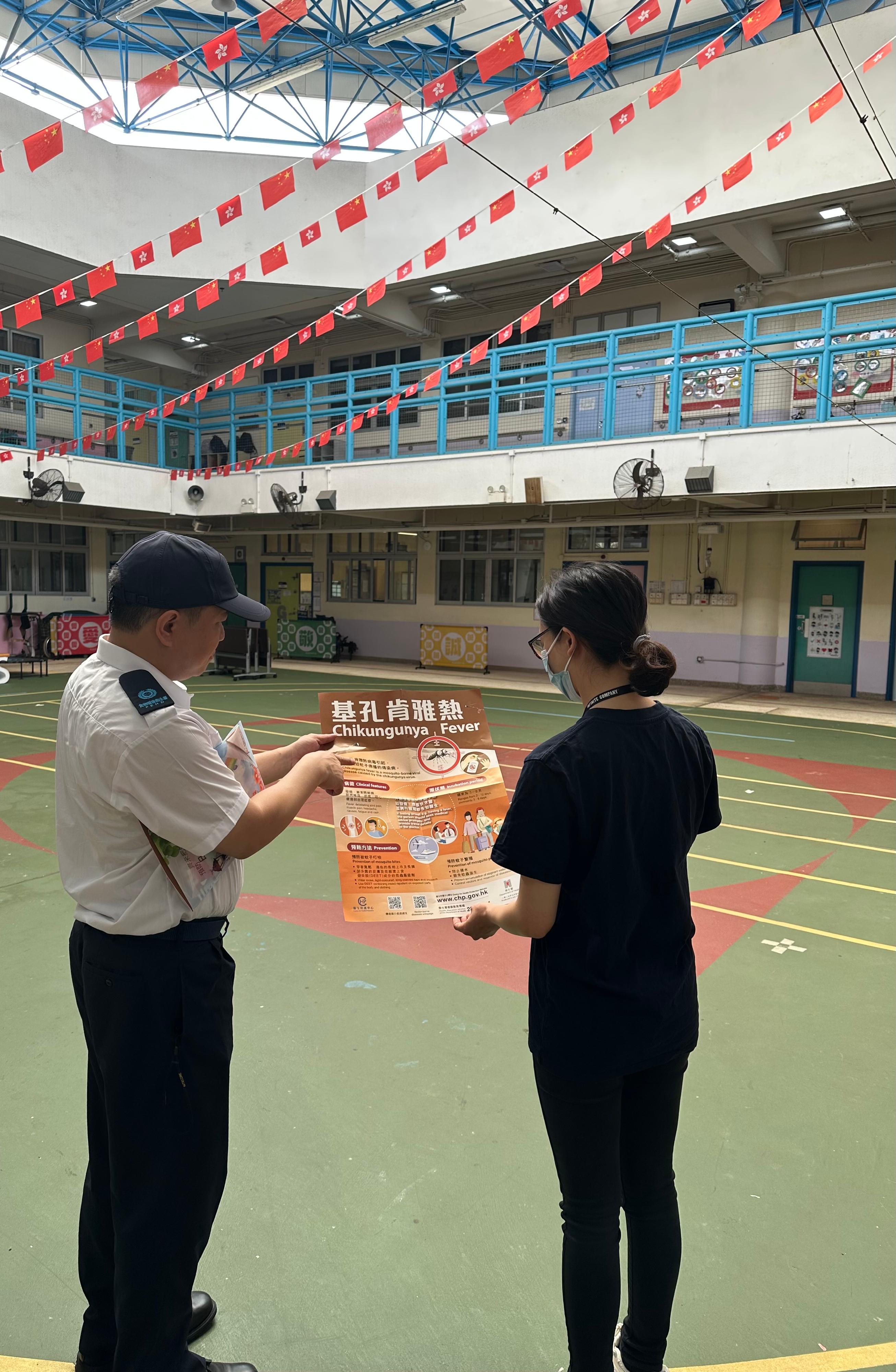 食物環境衞生署（食環署）今日（四月十三日）公布四月份第一批涵蓋13個監察地區的白紋伊蚊誘蚊器指數及密度指數。圖示食環署人員巡視葵青區青衣北的一所學校，並向學校代表派發宣傳海報及單張，提高防控蚊患的意識。
