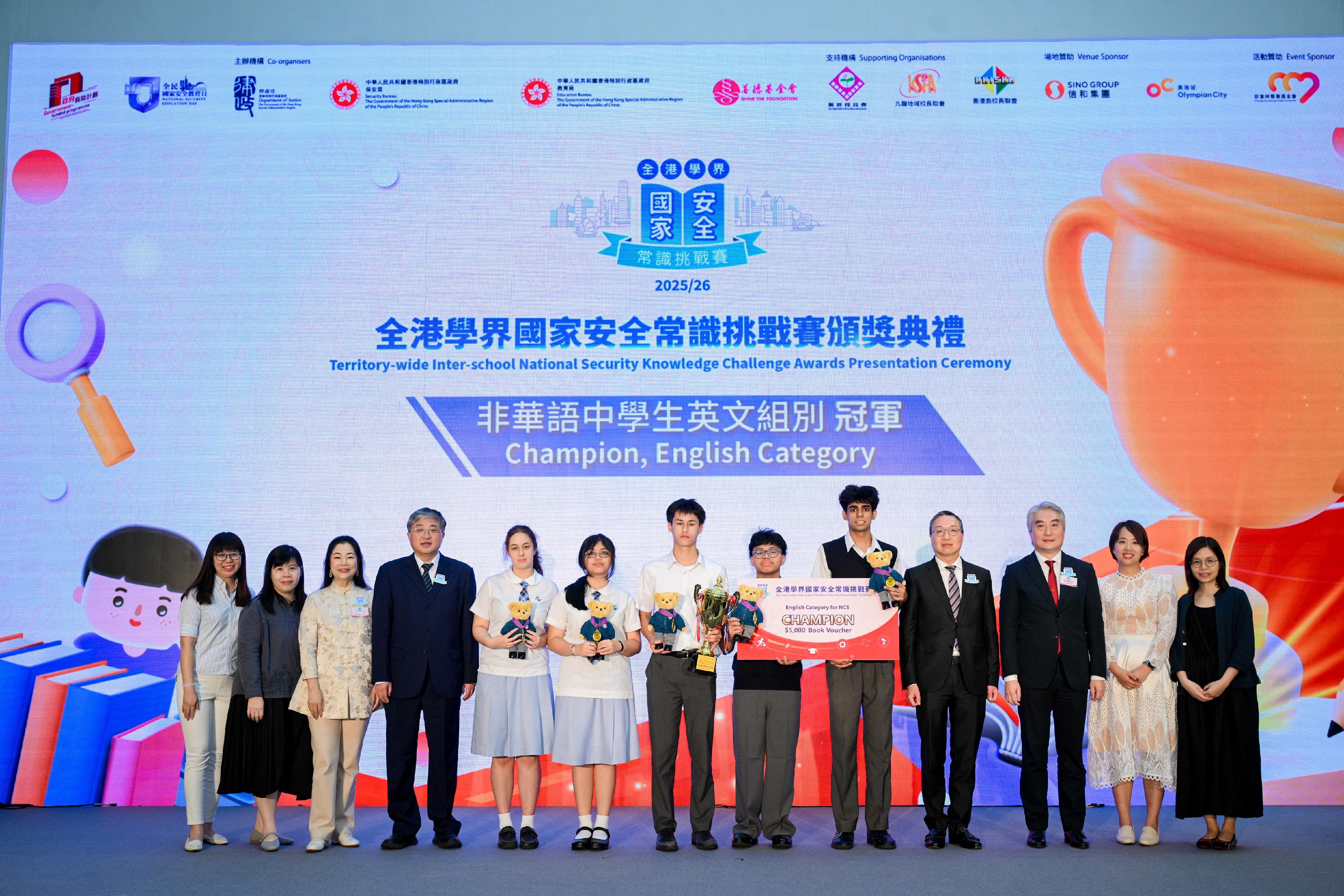 The finals and the award presentation ceremony of the Territory-wide Inter-school National Security Knowledge Challenge 2025/26, jointly organised by the Department of Justice, the Security Bureau, the Education Bureau and the Hong Kong Shine Tak Foundation, were held today (April 15). Photo shows the Secretary for Justice, Mr Paul Lam, SC (fourth right), presenting awards to the champion of team competition English section Ling Liang Church E Wun Secondary School.