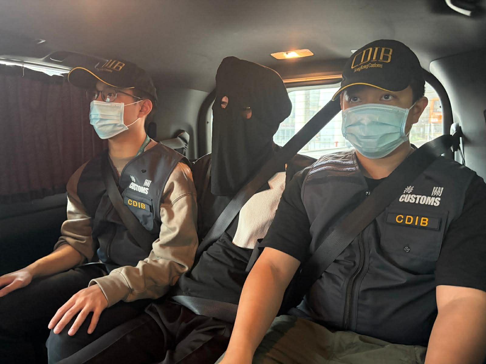 香港海關昨日（四月十五日）在香港國際機場偵破一宗行李藏毒的販毒案件，共檢獲約六公斤懷疑大麻花，估計市值共約一百二十萬元，以及九十一支未完稅香煙。圖示涉案的被捕人士（中）。