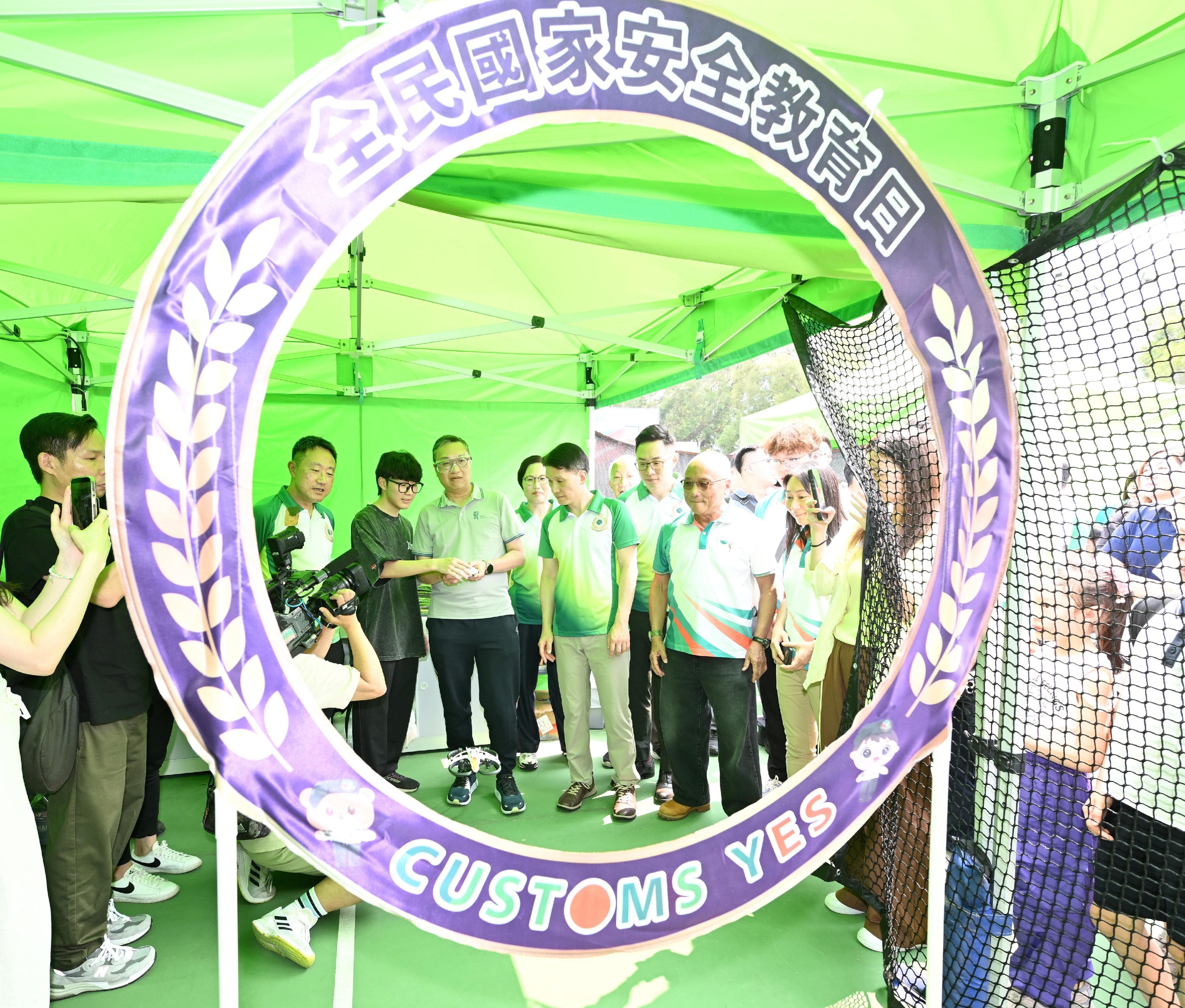 Hong Kong Customs today (April 18) held the Hong Kong Customs College Open Day. Photo shows &ldquo;Customs YES&rdquo; youth member introducing the national security-themed game booth to the Secretary for Justice, Mr Paul Lam, SC (third left).