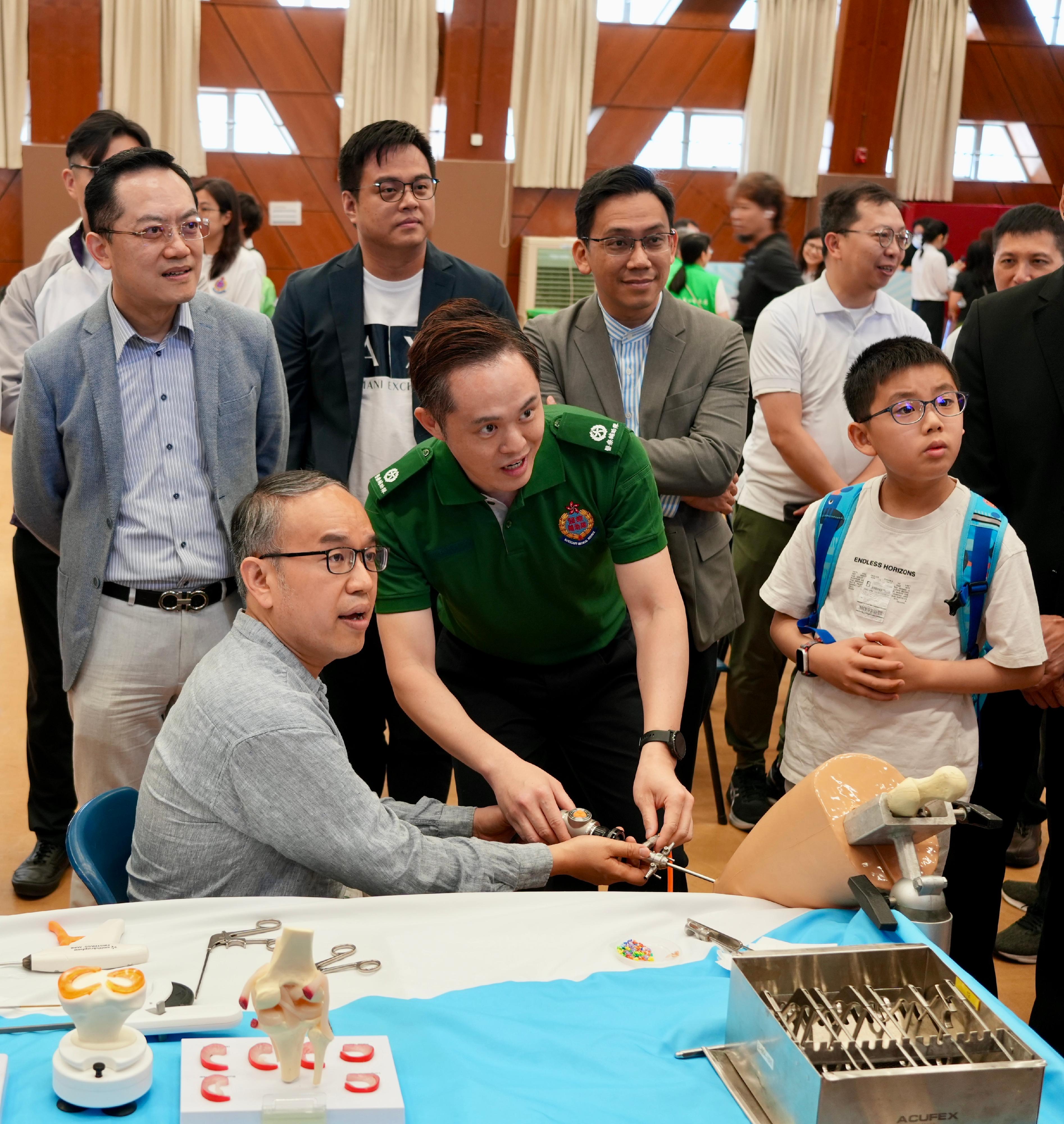 財經事務及庫務局局長許正宇（前排左）參觀展覽攤位。