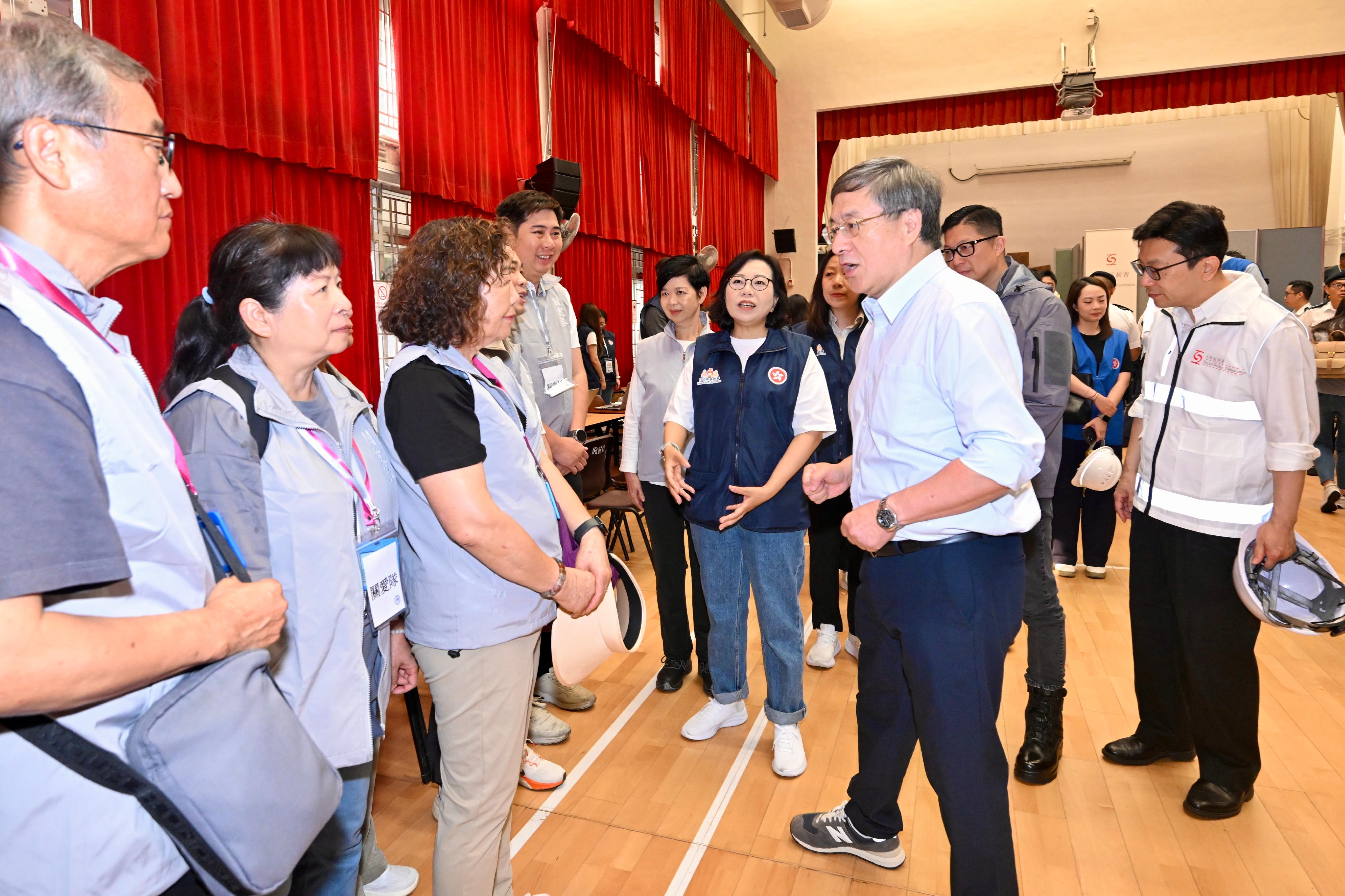 政務司副司長卓永興今日(四月二十日)上午聯同保安局局長鄧炳強、房屋局局長何永賢、民政及青年事務局局長麥美娟和勞工及福利局局長孫玉菡視察大埔宏福苑居民上樓安排的準備情況。圖示卓永興(右)在大埔廣福社區會堂與在場協助的地區服務及關愛隊伍隊員交談。