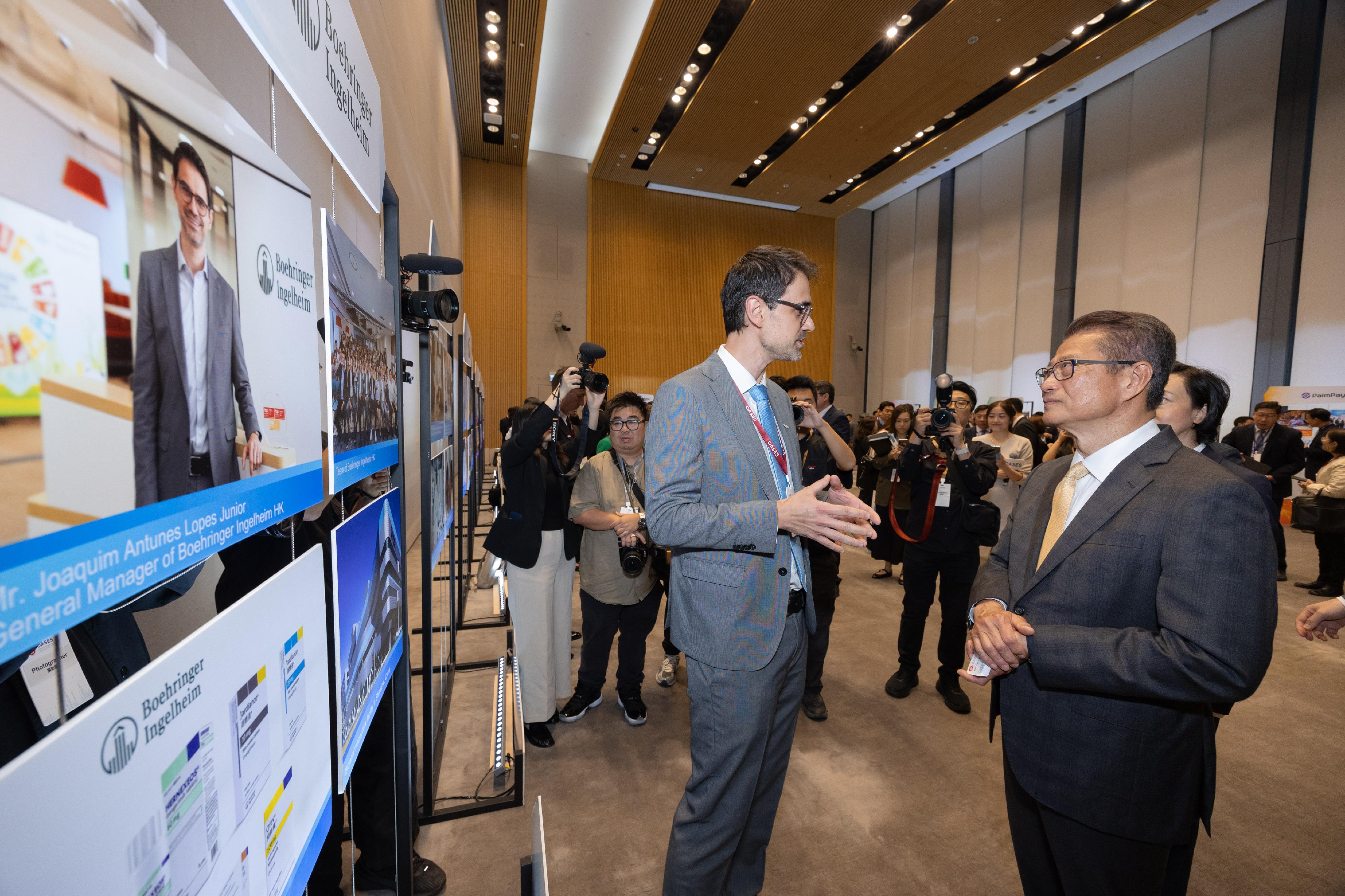 The Financial Secretary, Mr Paul Chan, attended the OASES Enterprises Signing Ceremony today (April 20). Photo shows Mr Chan (right) interacting with a representative of the strategic enterprise. 