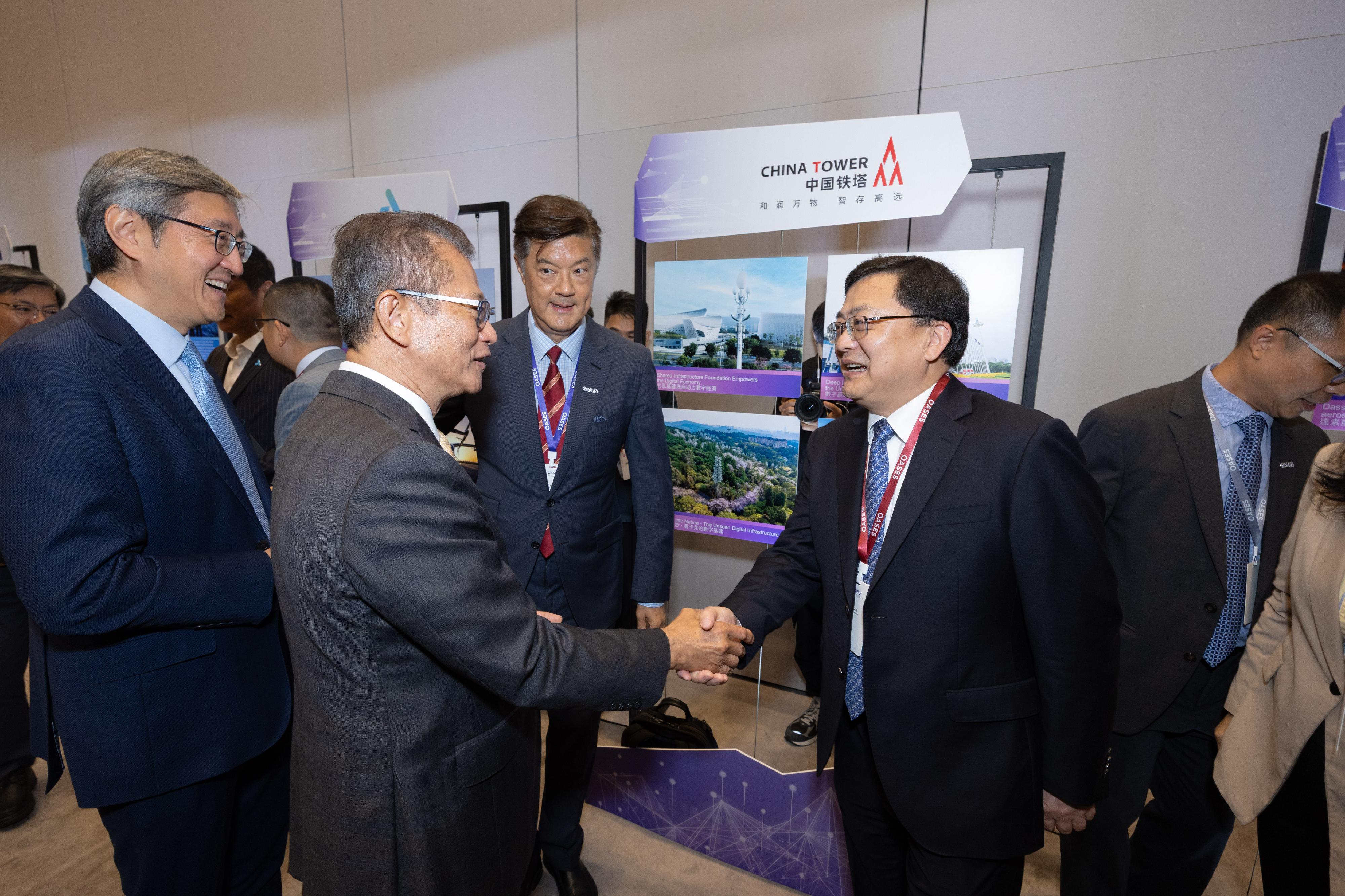 The Financial Secretary, Mr Paul Chan, attended the OASES Enterprises Signing Ceremony today (April 20). Photo shows Mr Chan (second left) interacting with a representative of the strategic enterprise.