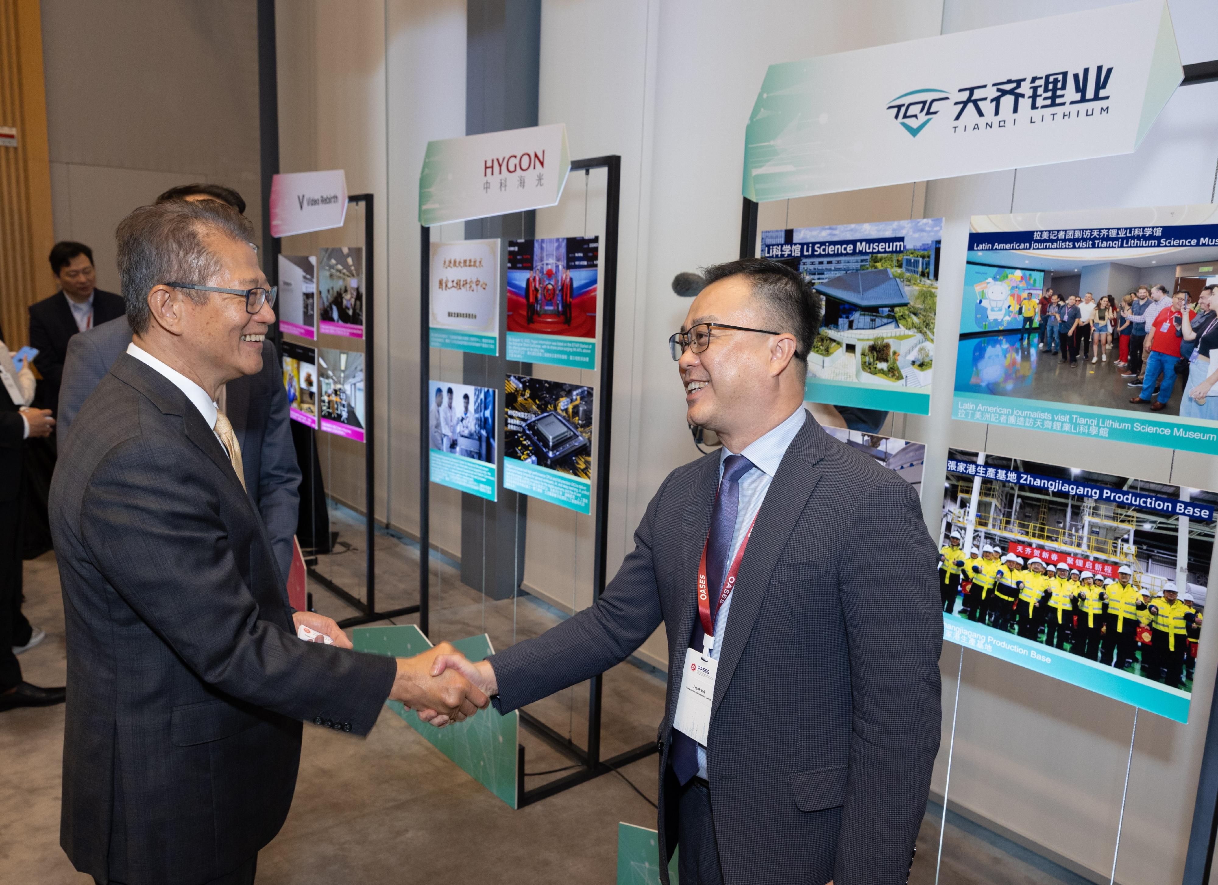 The Financial Secretary, Mr Paul Chan, attended the OASES Enterprises Signing Ceremony today (April 20). Photo shows Mr Chan (left) interacting with a representative of the strategic enterprise. 
