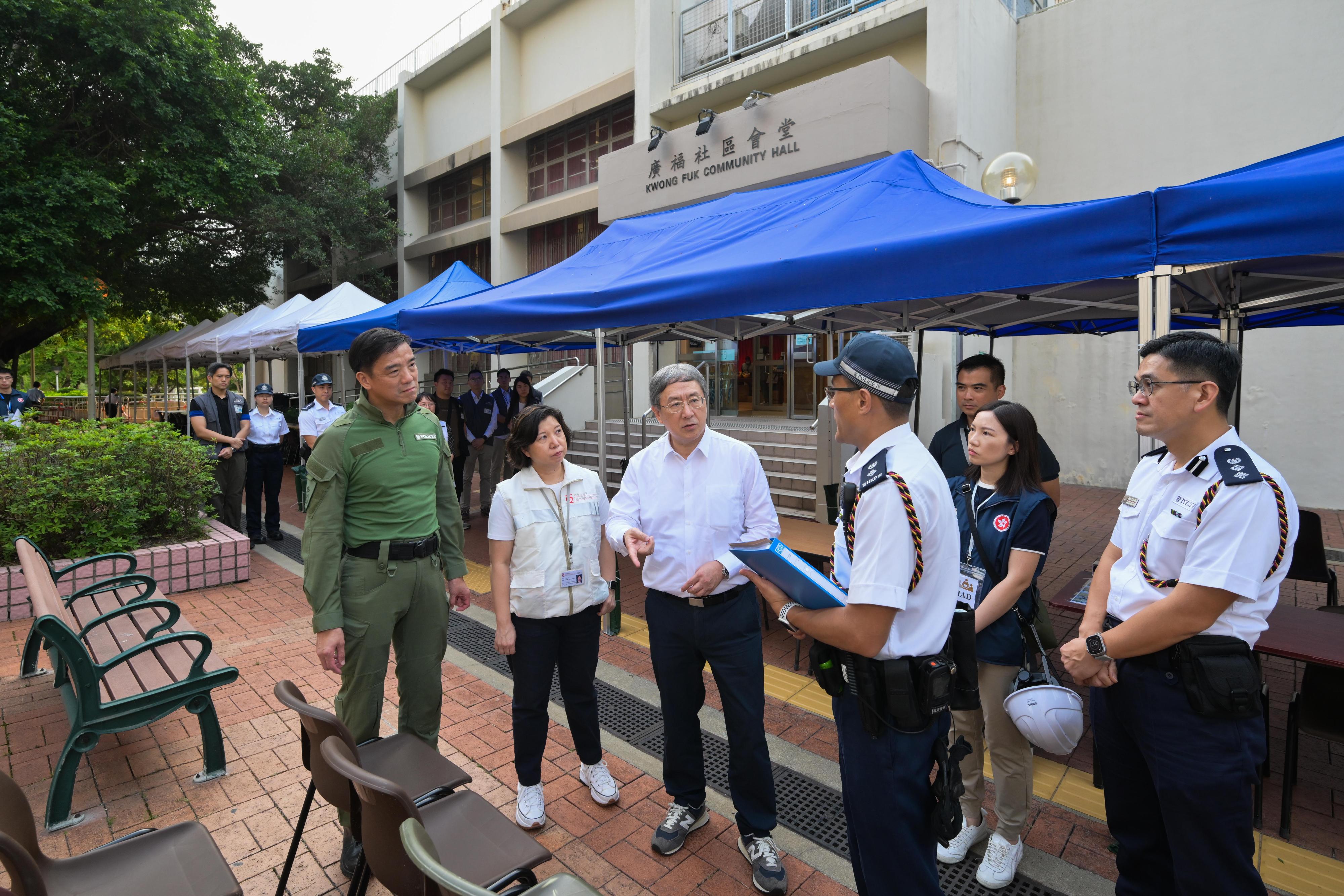 The Deputy Chief Secretary for Administration, Mr Cheuk Wing-hing, today (April 21) inspected the arrangements for Tai Po Wang Fuk Court residents returning to their units. Photo shows Mr Cheuk (third left) seeing for himself the operation of expanding the personal protective equipment donning area at Kwong Fuk Community Hall with more tables and chairs as well as more marquees for rain protection. Next to Mr Cheuk are the Deputy Director of Social Welfare (Services), Ms Maggie Leung (second left), and the Director of Operations of Hong Kong Police Force, Mr Lui Kam-ho (first left).
