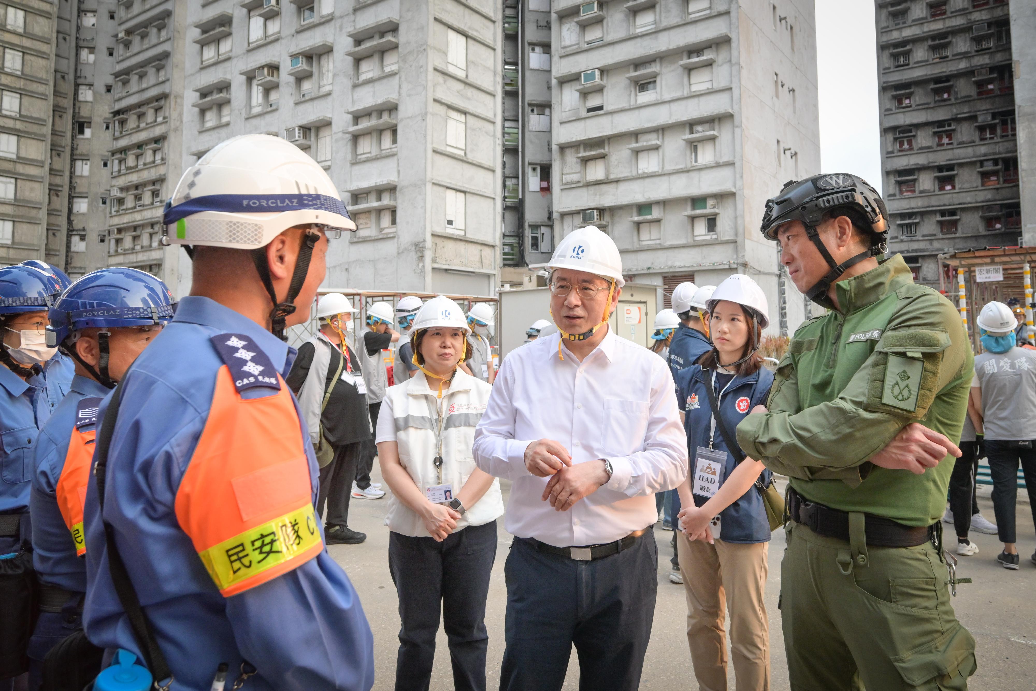 The Deputy Chief Secretary for Administration, Mr Cheuk Wing-hing, today (April 21) inspected the arrangements for Tai Po Wang Fuk Court residents returning to their units. Photo shows Mr Cheuk (third right) talking with a member of the Civil Aid Service. Next to Mr Cheuk is the Director of Operations of Hong Kong Police Force, Mr Lui Kam-ho (first right).
