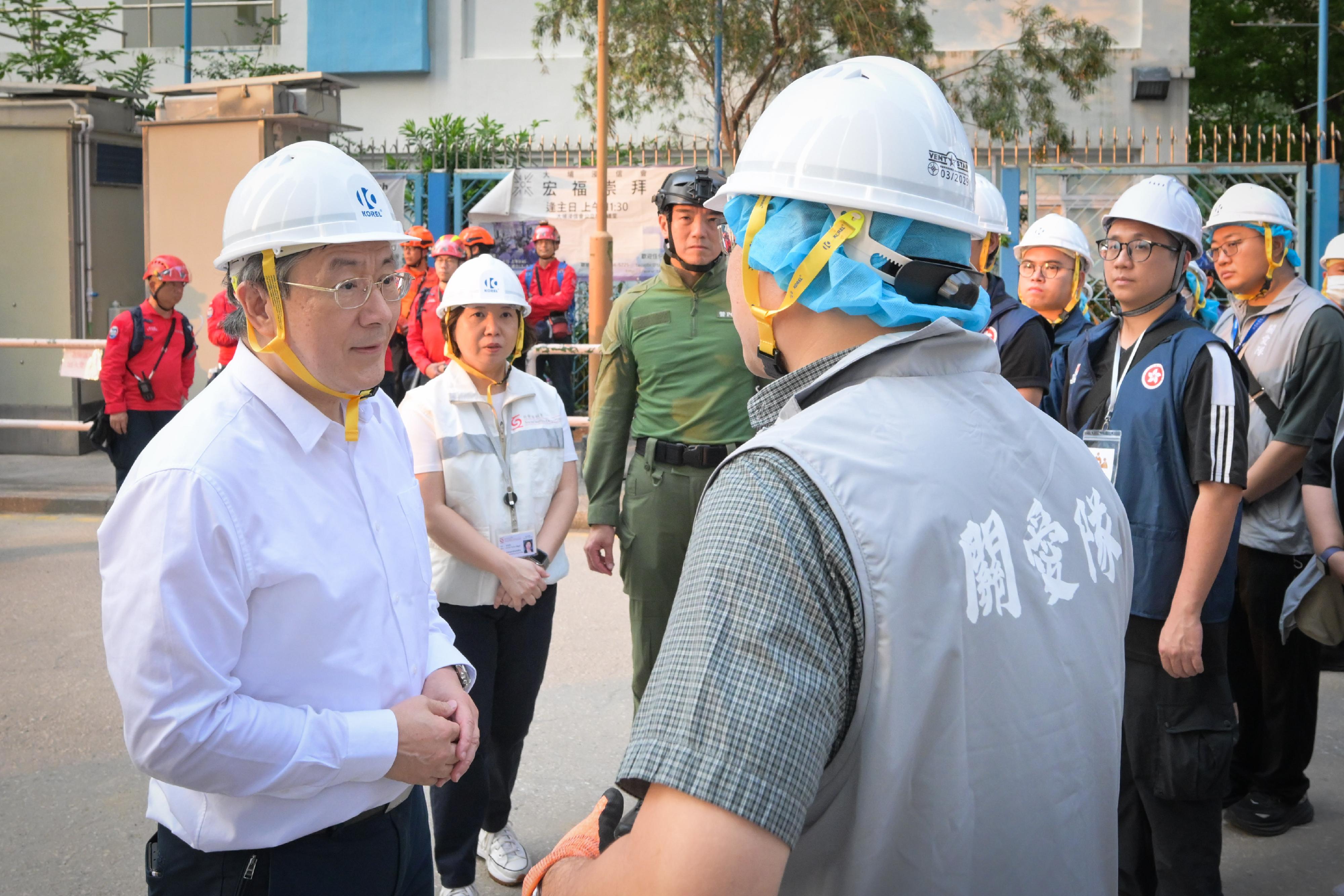 The Deputy Chief Secretary for Administration, Mr Cheuk Wing-hing, today (April 21) inspected the arrangements for Tai Po Wang Fuk Court residents returning to their units. Photo shows Mr Cheuk (left) expressing gratitude to members of the District Services and Community Care Teams for supporting residents.
