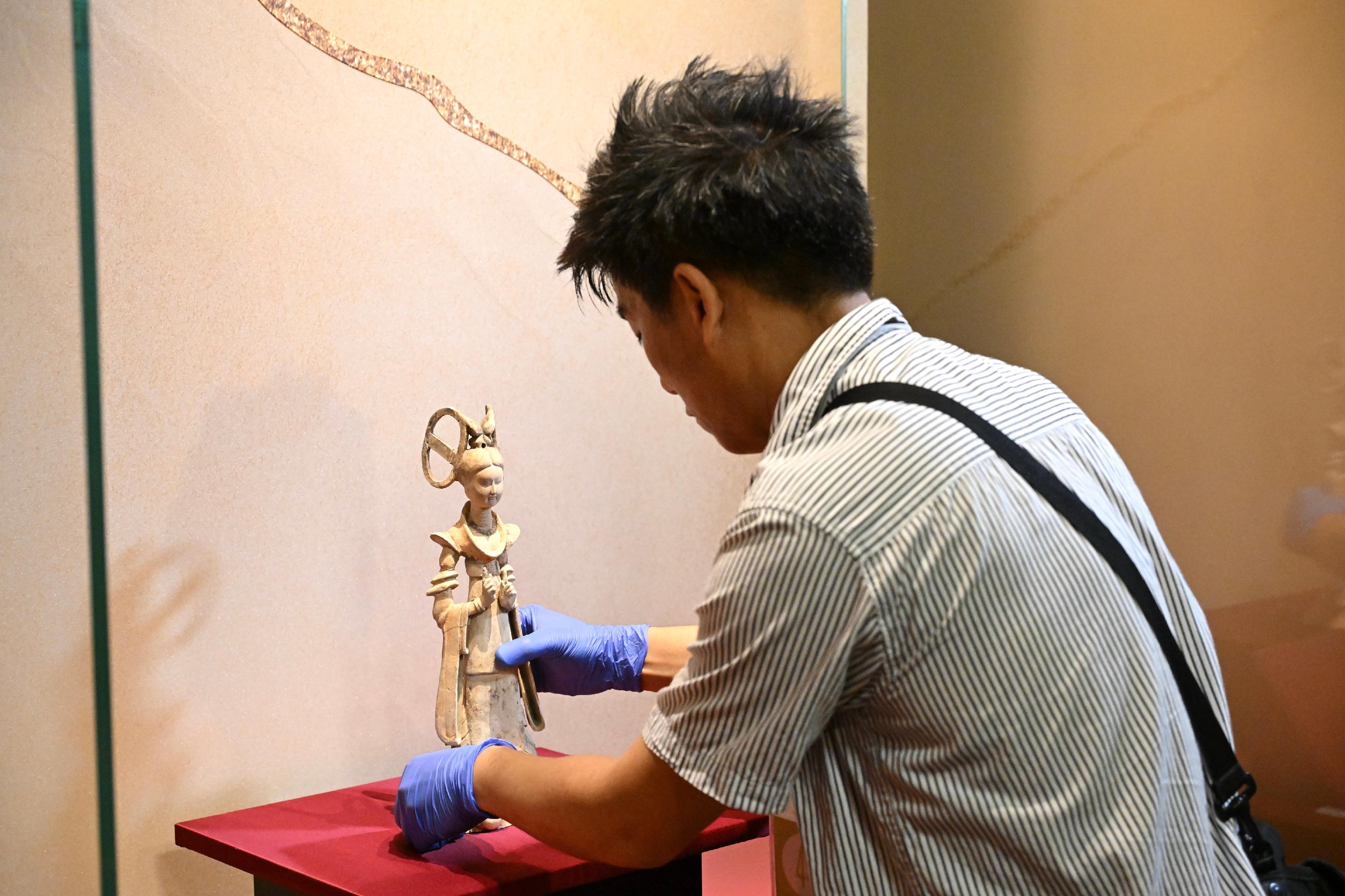 "The Hong Kong Jockey Club Series: Prosperity and Magnificence - Civilisation of the Sui and Tang Dynasties in Shaanxi Province" exhibition will be held at the Hong Kong Museum of History from April 25 to August 24. Photo shows a grade-one national treasure, a painted female figurine of dancer with a double-looped bun from the Tang dynasty, from a collection of the Changwu County Museum, being installed into a showcase by a conservator of the Conservation Office of the Leisure and Cultural Services Department.
