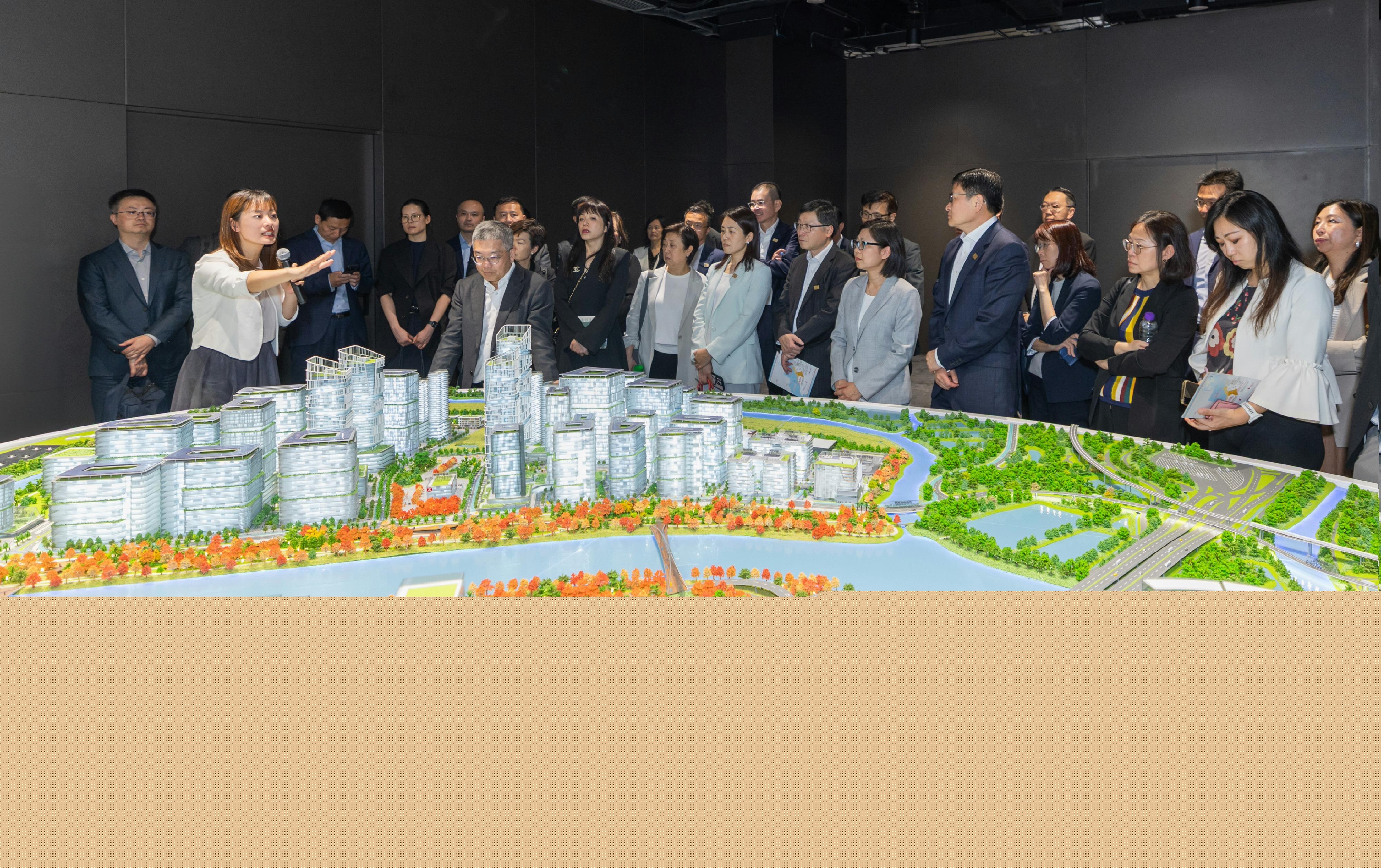 香港金融管理局與香港銀行公會今日（四月二十二日）宣布共同成立「北部都會區金融諮詢工作小組」，探討從融資方面積極配合北部都會區發展。圖示「北部都會區金融諮詢工作小組」參觀河套深港科技創新合作區香港園區並聽取創新科技及工業局副局長張曼莉（前排左一）介紹園區的發展。