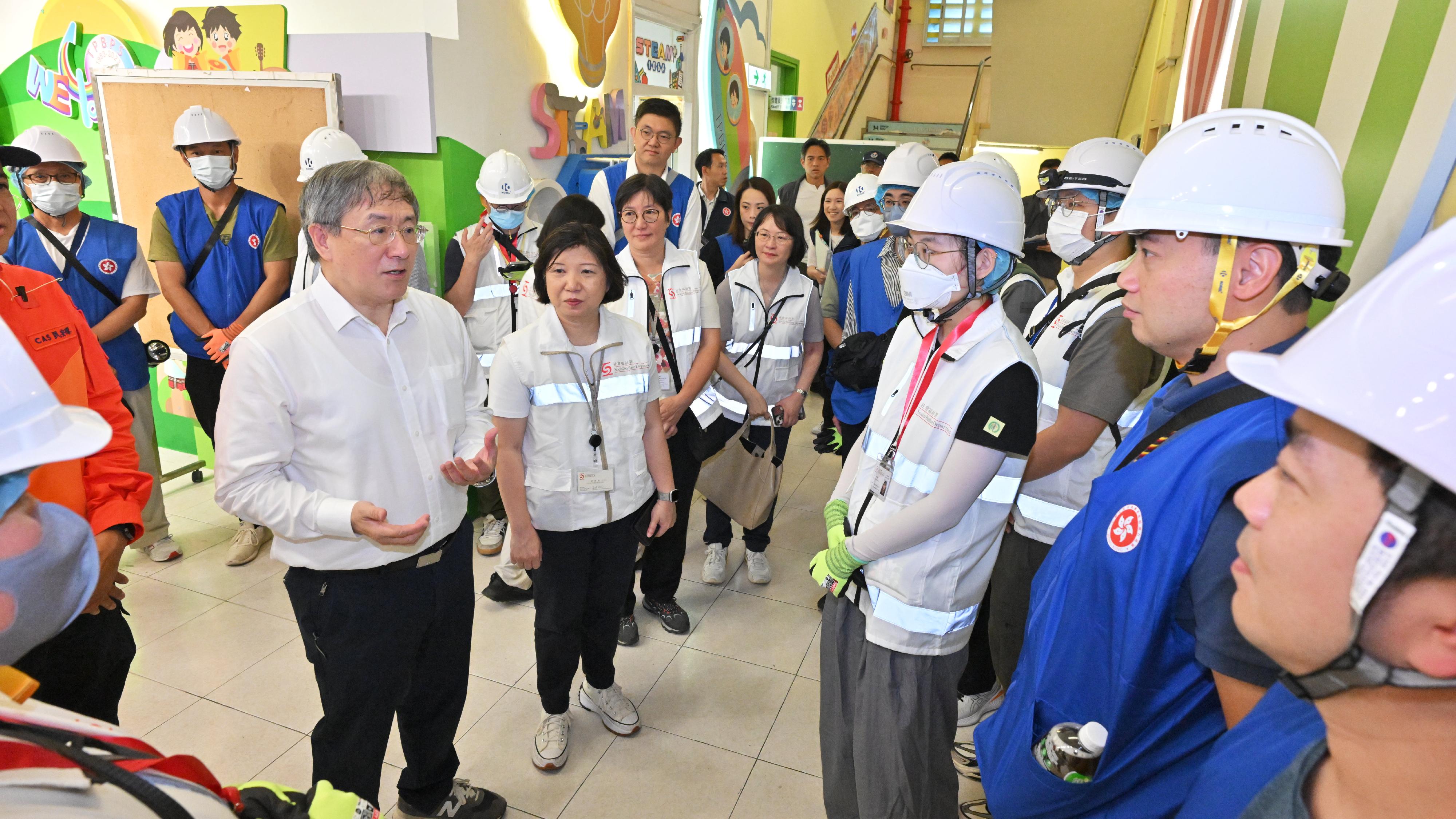 The Deputy Chief Secretary for Administration, Mr Cheuk Wing-hing, today (April 22) inspected the arrangements for Tai Po Wang Fuk Court residents returning to their units. Photo shows Mr Cheuk (first left) encouraging the dedicated teams stationed upstairs, who are getting ready to set off at Tai Po Baptist Public School. The dedicated teams, comprising social workers of the Social Welfare Department, clinical psychologists and mobilised civil servants, are stationed on different levels to provide support for residents. Looking on is the Deputy Director of Social Welfare (Services), Ms Maggie Leung (second left).
