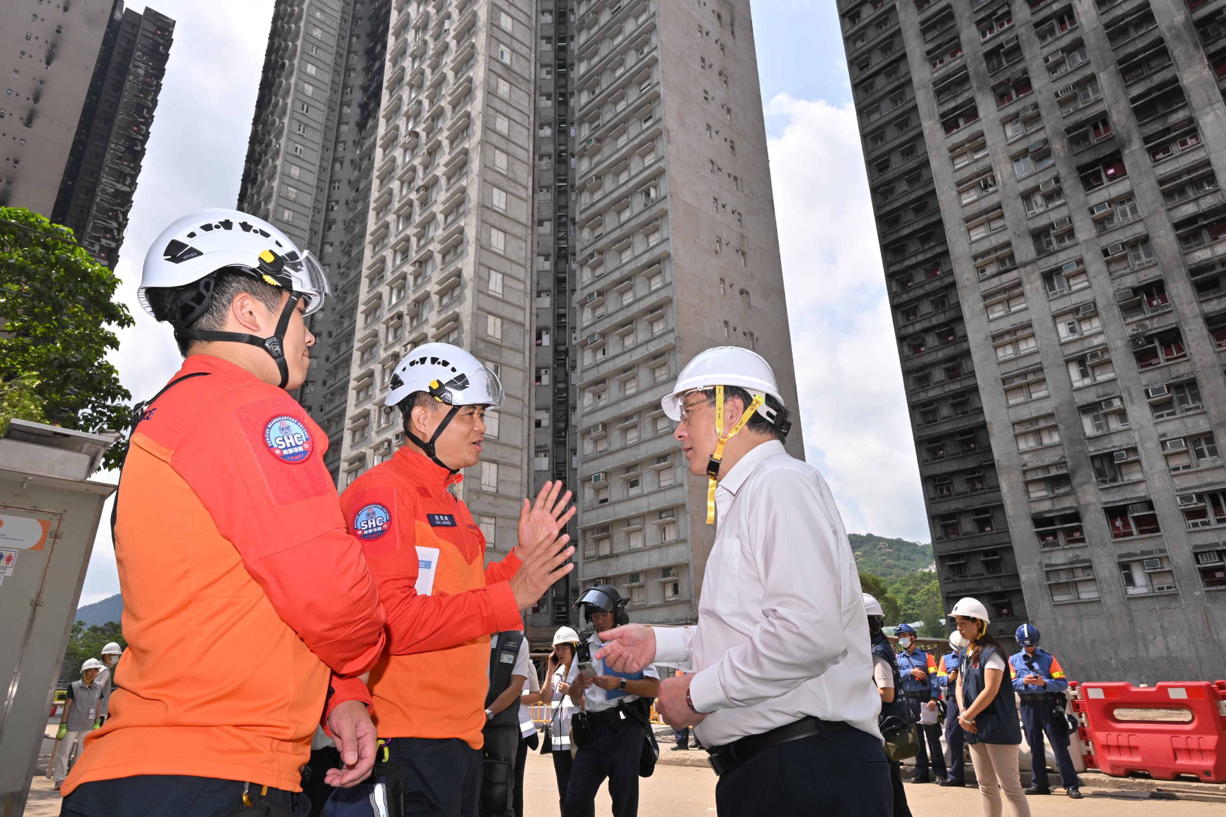 The Deputy Chief Secretary for Administration, Mr Cheuk Wing-hing, today (April 22) inspected the arrangements for Tai Po Wang Fuk Court residents returning to their units. Photo shows Mr Cheuk (right) receiving a briefing by the Chief Staff Officer of the Civil Aid Service, Mr Leung Kwun-hong (left), on the work for residents returning to their units.
