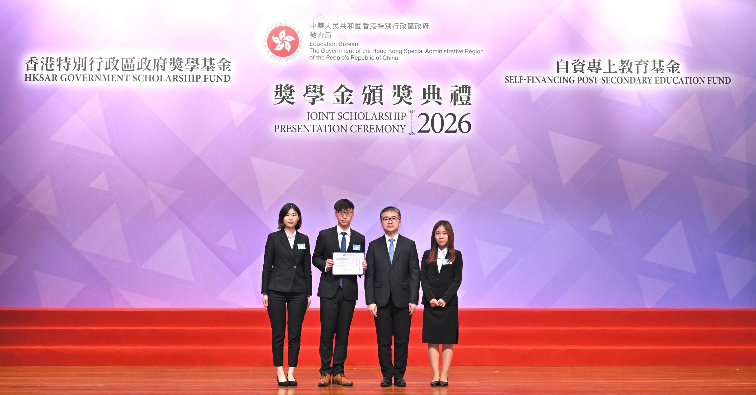 教育局今日（四月二十三日）舉行香港特別行政區政府獎學基金及自資專上教育基金獎學金頒獎典禮。圖示署理教育局局長施俊輝博士（右二）頒發獎狀予獲得香港特別行政區政府獎學基金獎學金的學生。