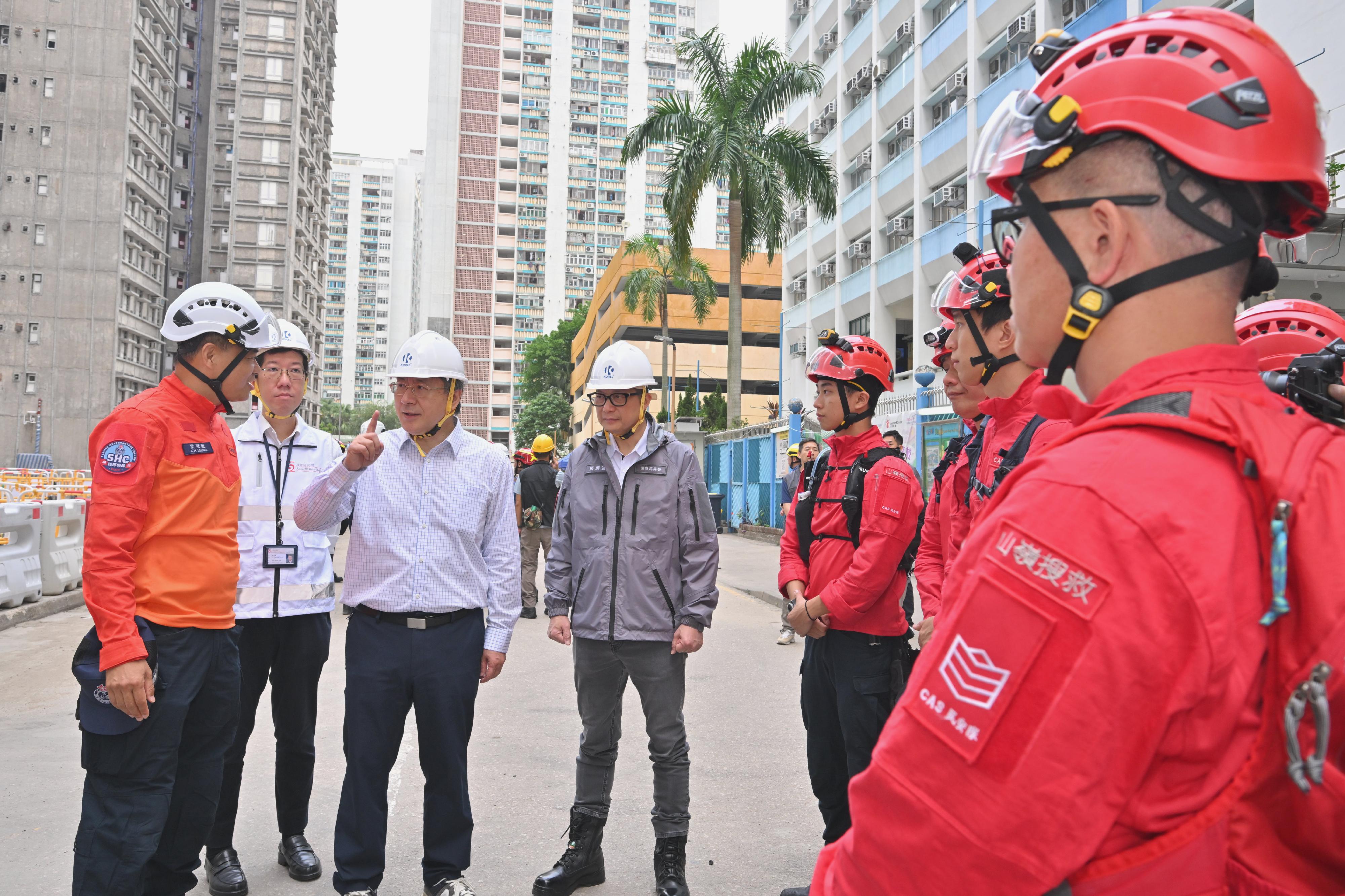 政務司副司長卓永興和保安局局長鄧炳強今日（四月二十三日）視察大埔宏福苑宏昌閣和宏仁閣居民上樓安排。圖示卓永興（左三）勉勵民眾安全服務隊繼續努力，全力協助上樓居民。