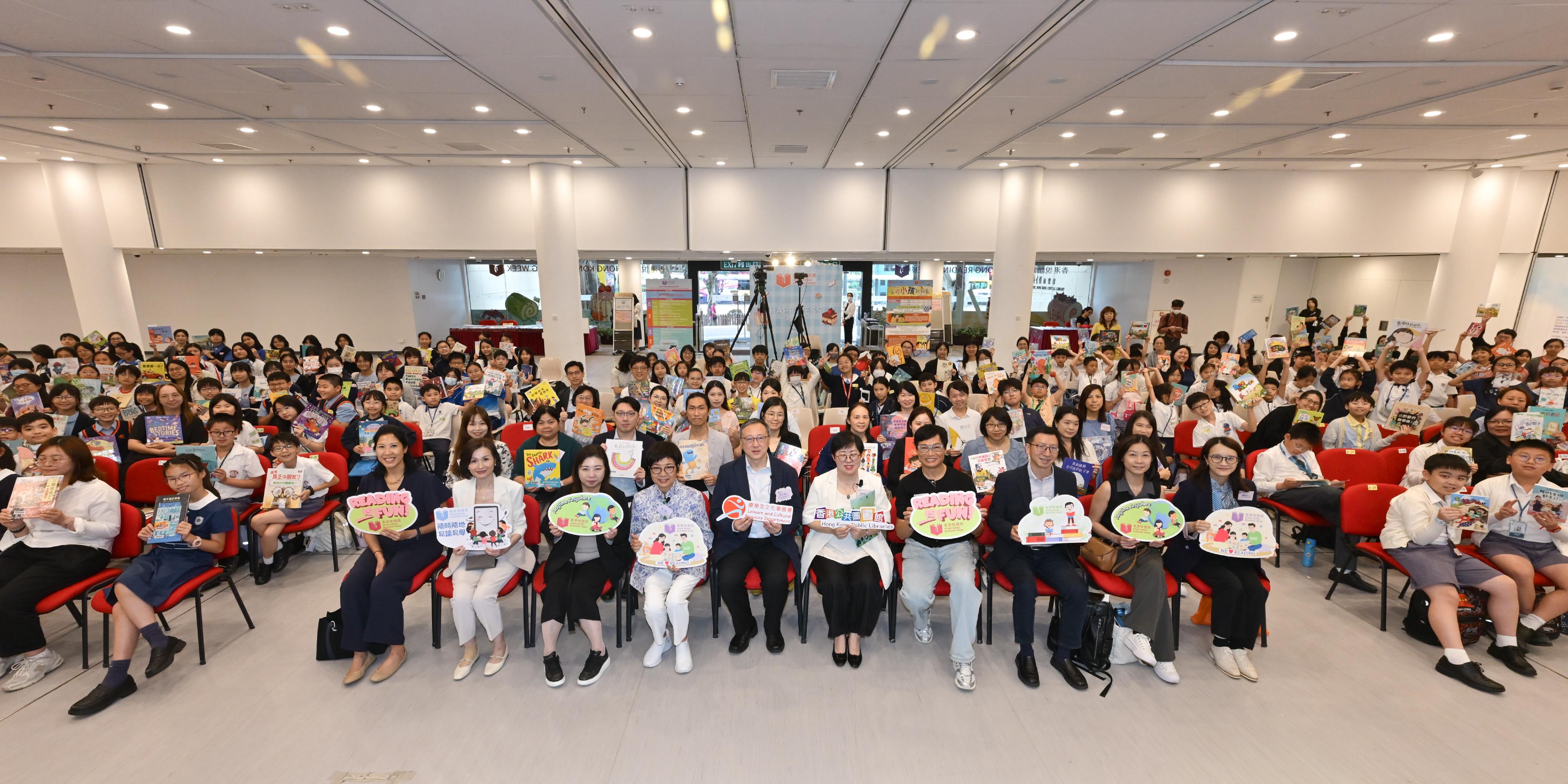 康樂及文化事務署（康文署）轄下香港公共圖書館今日（四月二十三日）與不同持份者合作設立共讀點，舉行「共讀半小時」活動。康文署助理署長（圖書館及發展）李子俊與參加全港中小學校際中文閱讀競賽的學生，一同在香港中央圖書館參與「共讀半小時」活動 。圖示李子俊（前排左七）、公共圖書館諮詢委員會主席羅乃萱（前排左六）、香港學校圖書館主任協會會長黃毅娟（前排右七）與其他嘉賓和學生合照。
