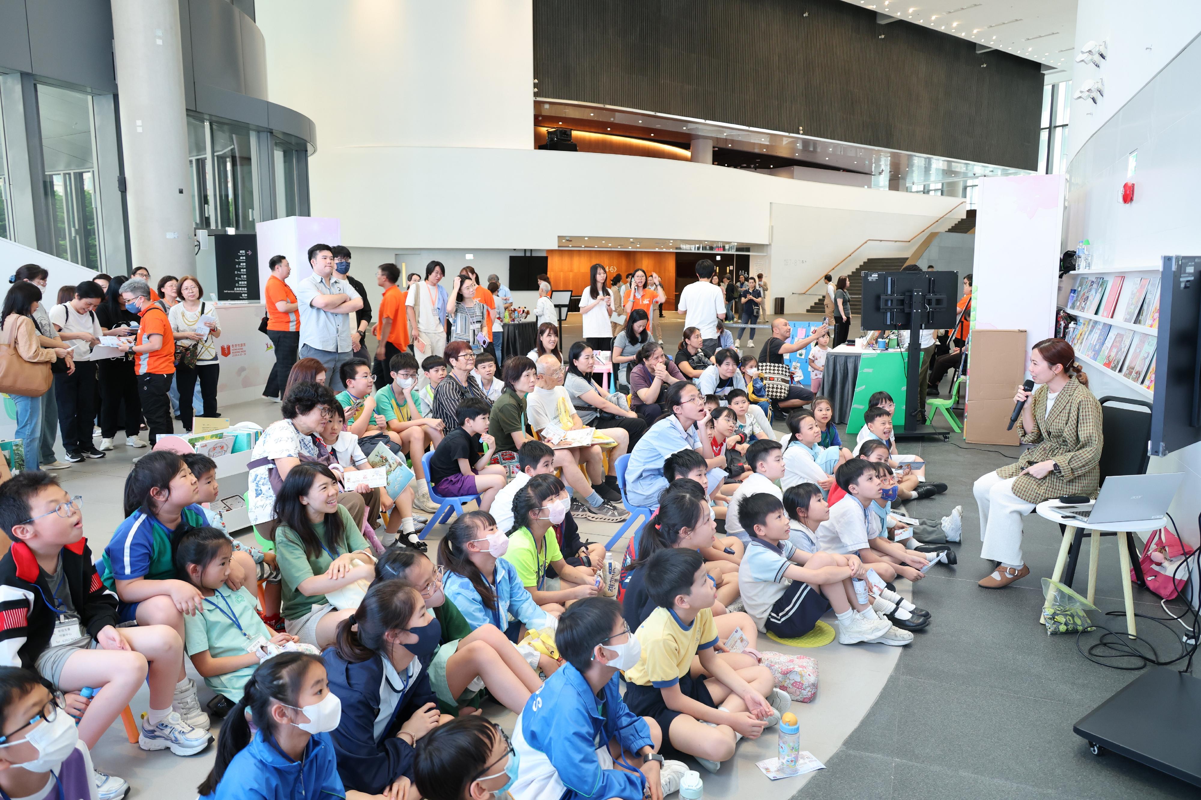 The Hong Kong Public Libraries (HKPL) of the Leisure and Cultural Services Department today (April 23) collaborated with stakeholders to set up reading locations for "Read Together for Half an Hour" activities. The HKPL and the Hans Andersen Club also co-organised "Joyful Family Reading Carnival" at the East Kowloon Cultural Centre. Photo shows author of children's picture books Amy Chai (first right) sharing with children the joy of reading.