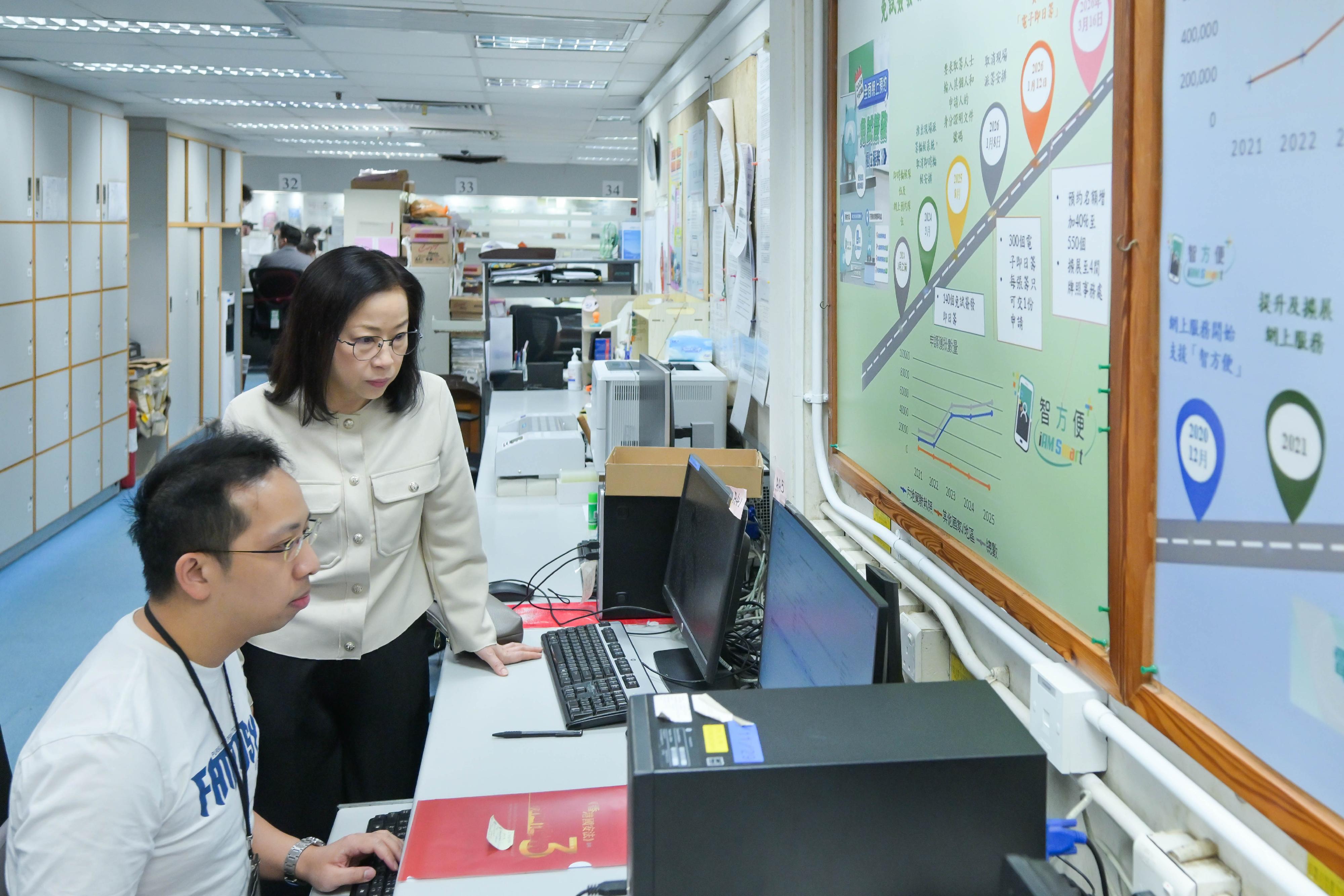 The Commissioner for Transport, Miss Winnie Tse, today (April 23) visited the Hong Kong Licensing Office at United Centre, Admiralty. She was briefed on the operations and application situation following the full implementation of online appointments for counter services for direct issue of the Hong Kong Full Driving Licence since March 16, coupled with a 40 per cent increase in booking quotas on each working day and service extension to the four Licensing Offices across the territory. Photo shows Miss Tse (right) observing how the system conducts identity verification through preliminary vetting of identity documents and driving licences uploaded by applicants, aided by artificial intelligence technologies, while staff verify the originals of supporting documents required.