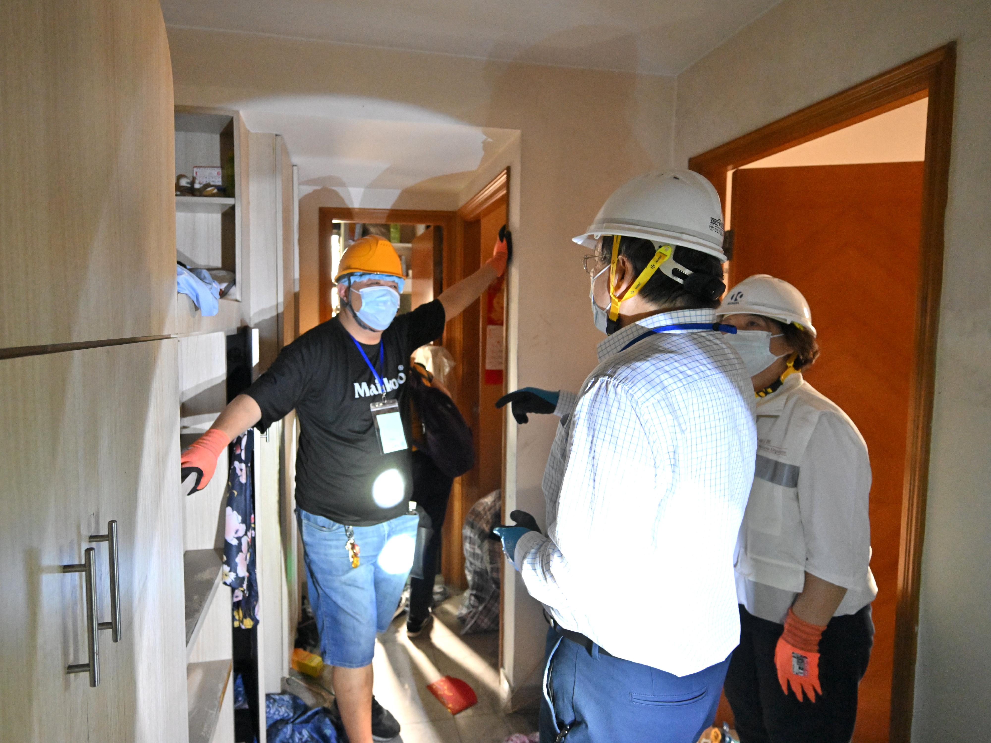 The Deputy Chief Secretary for Administration, Mr Cheuk Wing-hing, today (April 23) went upstairs to talk with two households returning to their units at Wang Cheong House of Wang Fuk Court in Tai Po to learn about their situation in collecting their belongings and to hear their views on the arrangements. Both households said that their units were not seriously damaged and that many items could be retrieved, and they hoped to return to their units one more time to collect more belongings. Mr Cheuk expressed his understanding of the residents&rsquo; wishes and said that the Government is actively following up on the arrangements for them to return to their units again.Photo shows Mr Cheuk (centre) talking with a Wang Cheong House resident inside a unit.