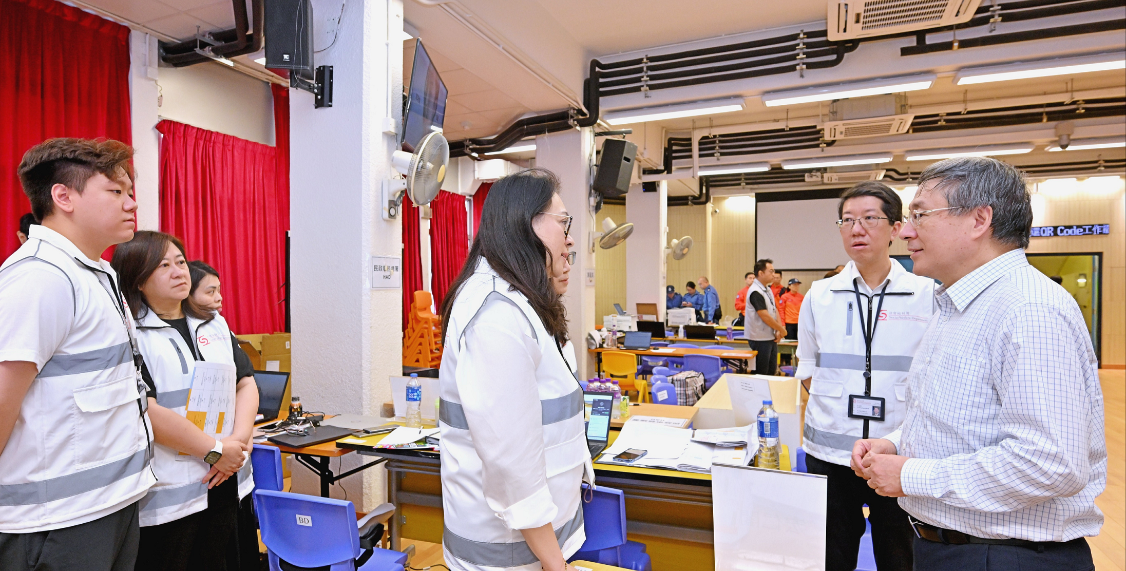 The Deputy Chief Secretary for Administration, Mr Cheuk Wing-hing, today (April 23) inspected the arrangements for residents of Wang Cheong House and Wang Yan House at Wang Fuk Court in Tai Po returning to their units. Photo shows Mr Cheuk (right) talking with staff members of the Social Welfare Department (SWD) at the Joint Command Centre to understand their support measures. The SWD has stepped up support for residents in need, including arranging clinical psychologists and social workers to accompany them throughout the process. Looking on is the Director of Social Welfare, Mr Edward To (second right).