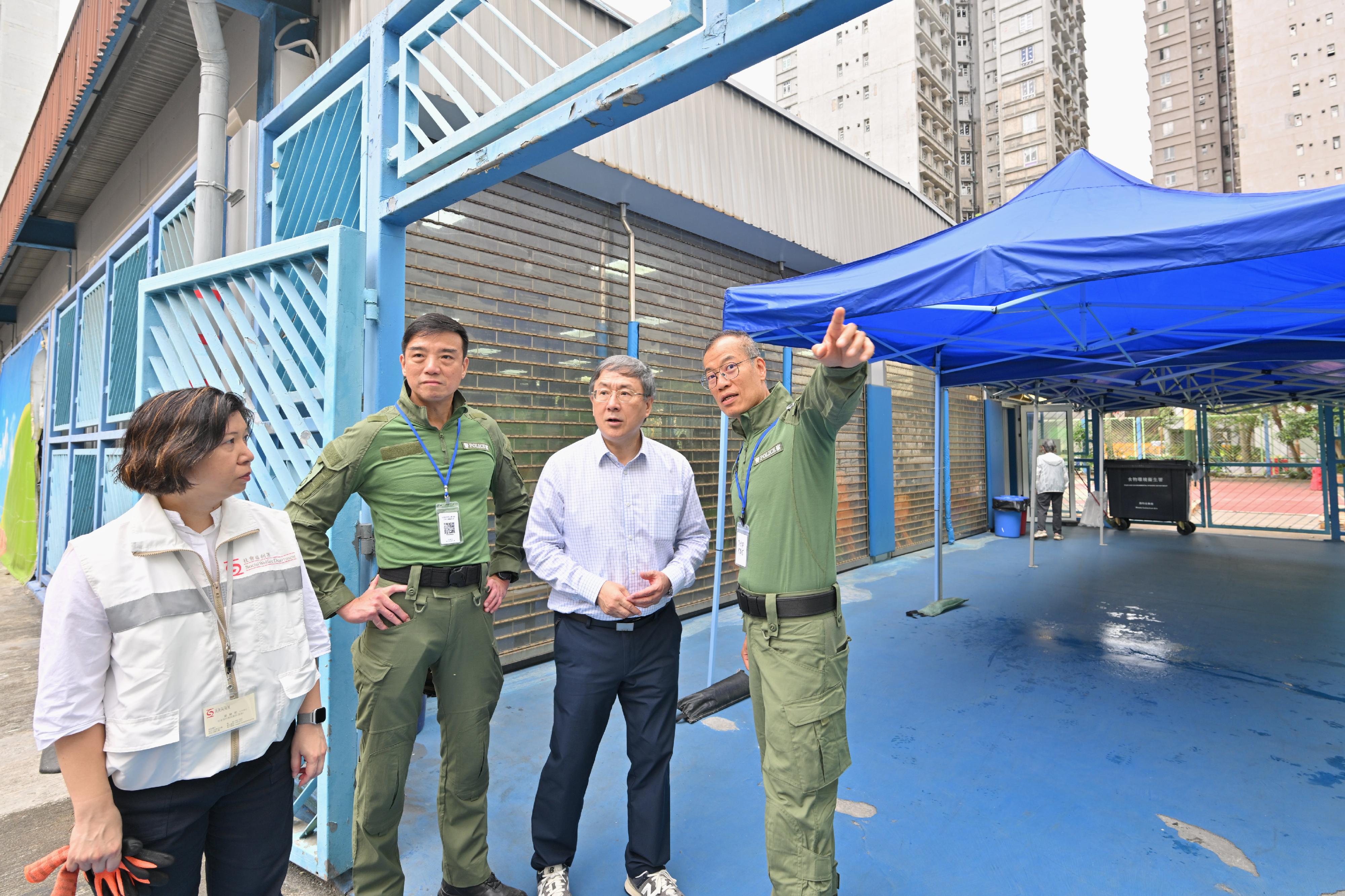 The Deputy Chief Secretary for Administration, Mr Cheuk Wing-hing, today (April 23) inspected the arrangements for residents of Wang Cheong House and Wang Yan House at Wang Fuk Court in Tai Po returning to their units. Photo shows Mr Cheuk (second right) being briefed by the Deputy Commissioner of Police (Operations), Mr Yip Wan-lung (first right), on the setting up of a covered passage with marquees at Tai Po Baptist Public School.