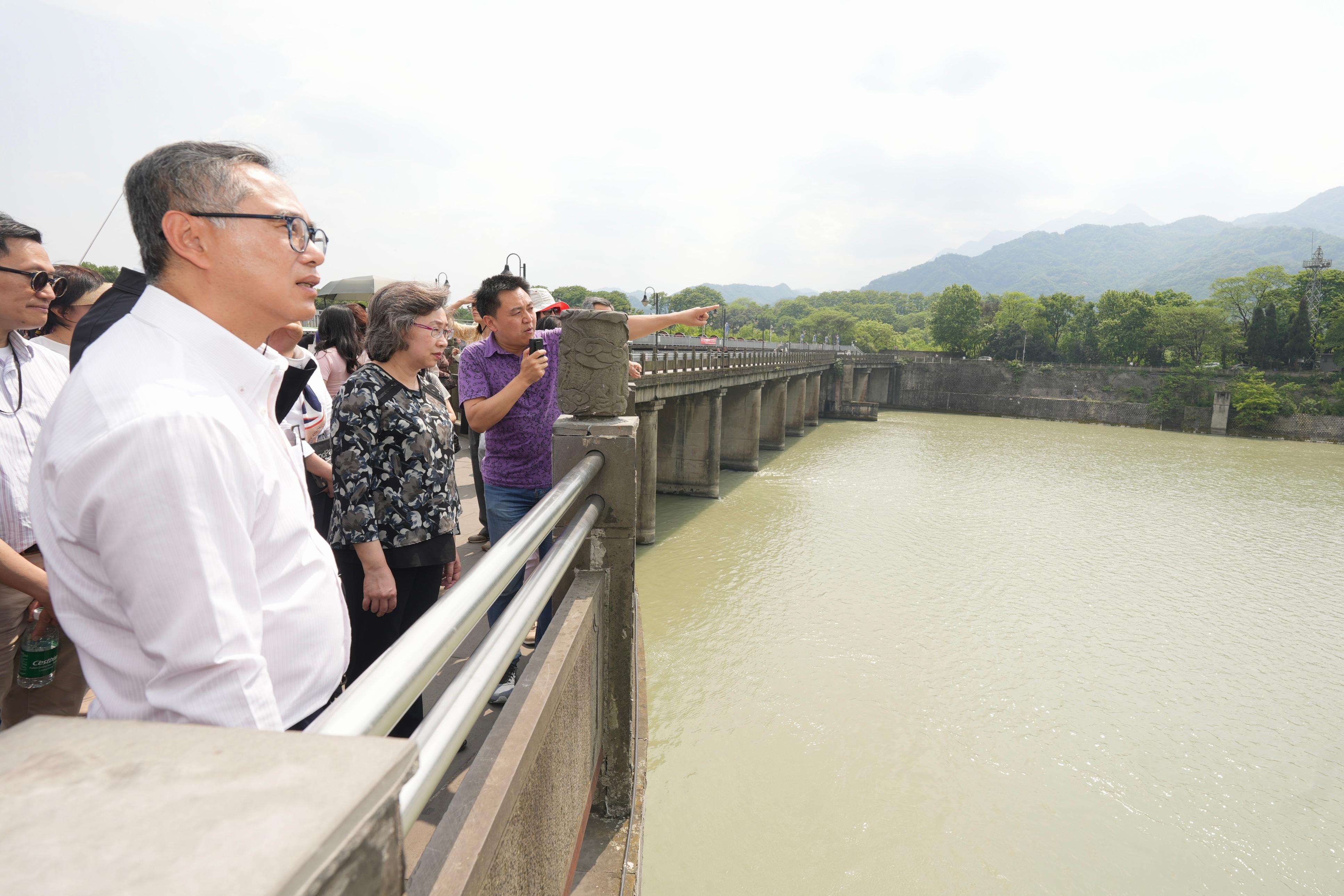A delegation of Permanent Secretaries and Heads of Departments of the Hong Kong Special Administrative Region Government on a national affairs study visited the Dujiangyan Irrigation System today (April 24) to learn how the long-established and large-scale irrigation system benefits the public. Photo shows the Secretary for the Civil Service, Mrs Ingrid Yeung (front row, centre), and the Permanent Secretary for Development (Works), Mr Ricky Lau (front row, first left), listening to a staff member's briefing on the design of the irrigation system.