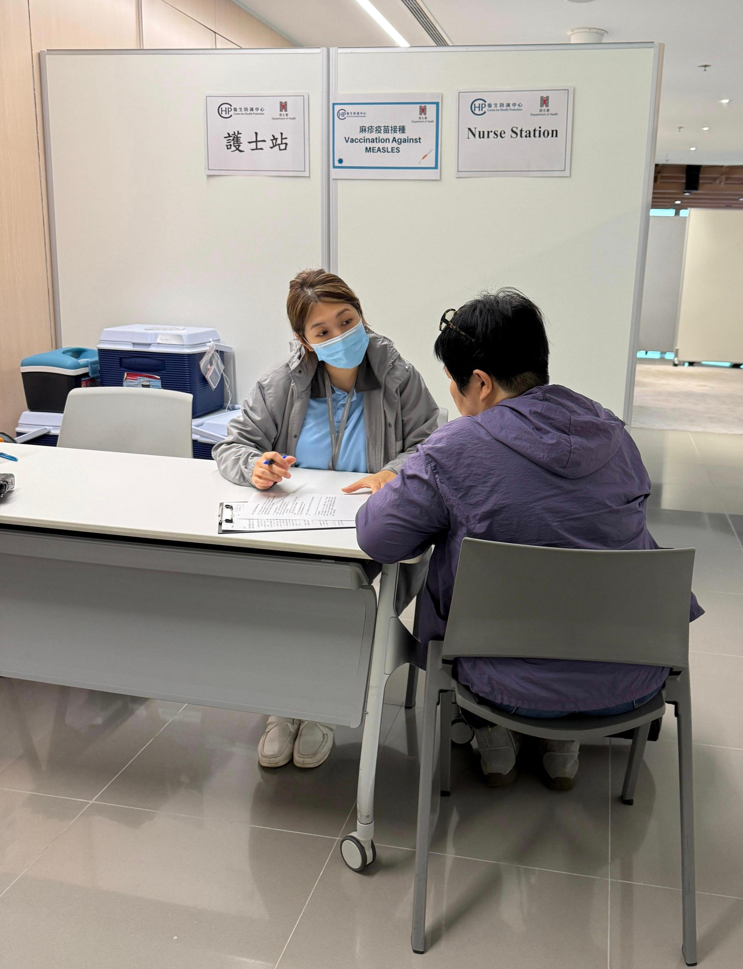 The Centre for Health Protection (CHP) of the Department of Health today (April 24) started to provide eligible airport staff with a free measles vaccination service at the airport. The aim is to strengthen herd immunity within the airport community, safeguard public health and prevent the spread of the virus. Photo shows a CHP staff member conducting an assessment before an airport staff member receives a vaccination. 