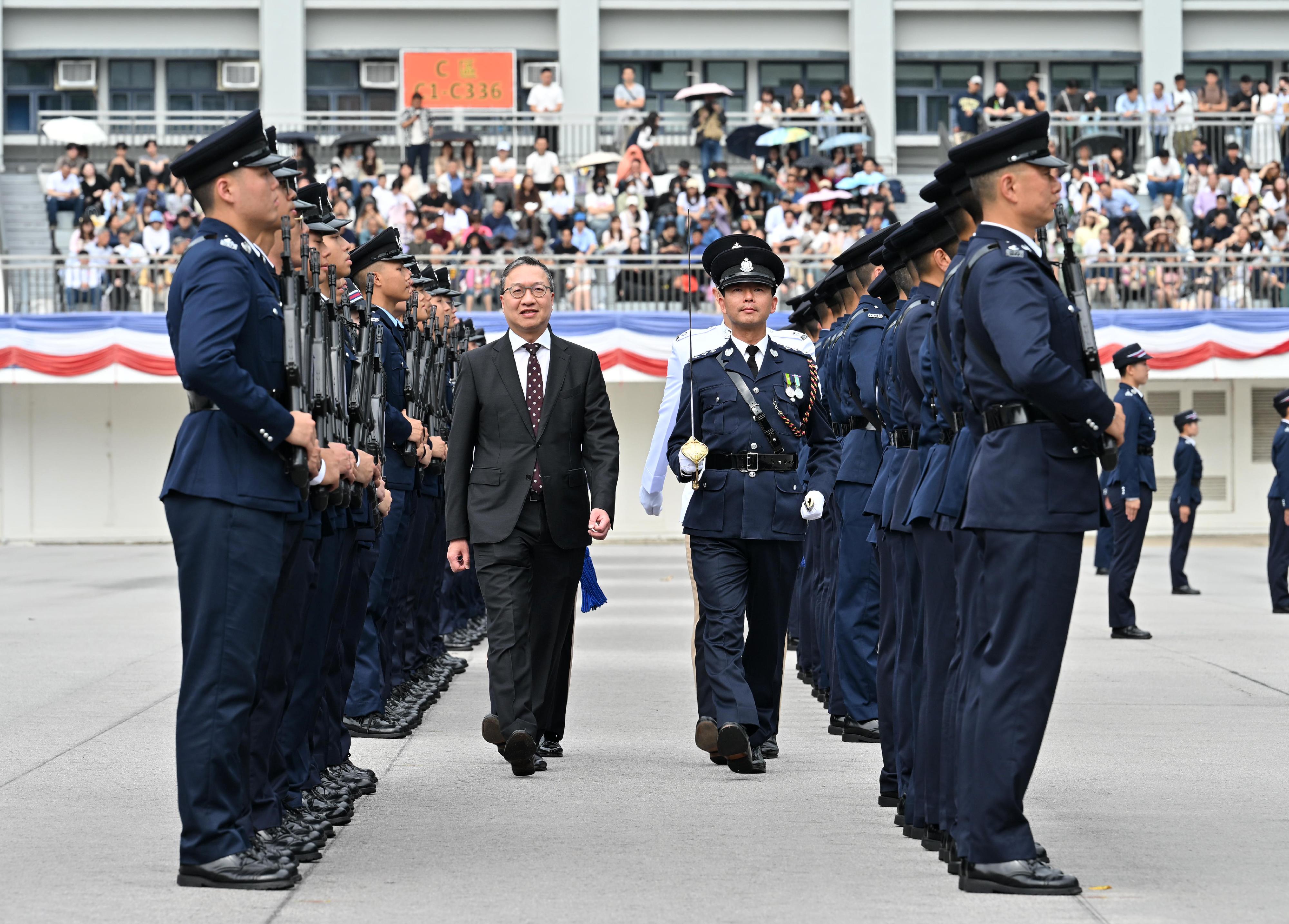 The Secretary for Justice, Mr Paul Lam, SC, inspects a passing-out parade as reviewing officer at the Hong Kong Police College today (April 25).