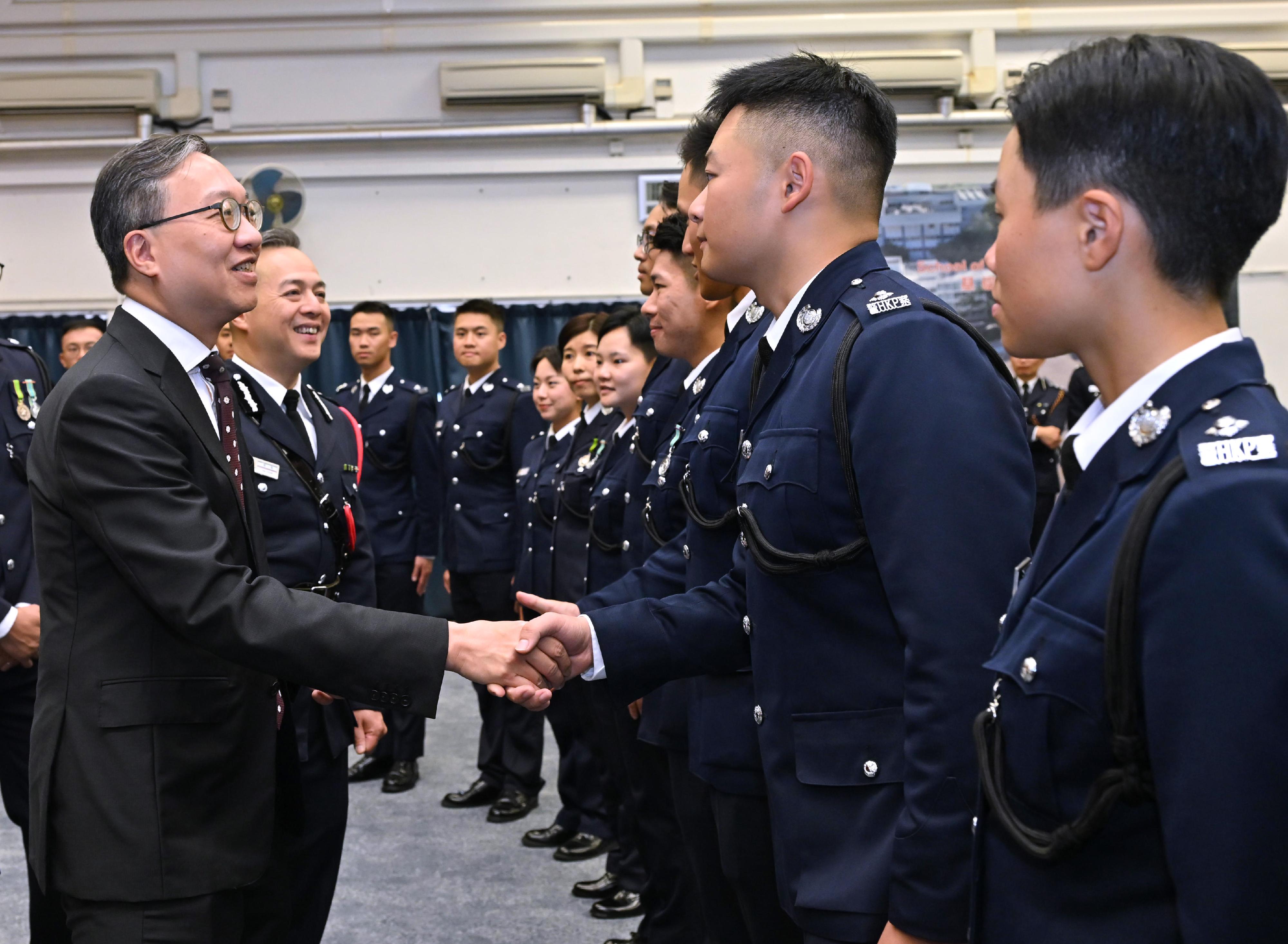 The Secretary for Justice, Mr Paul Lam, SC (first left), and the Commissioner of Police, Mr Chow Yat-ming (second left), congratulate the probationary inspectors after the passing-out parade held at the Hong Kong Police College today (April 25).