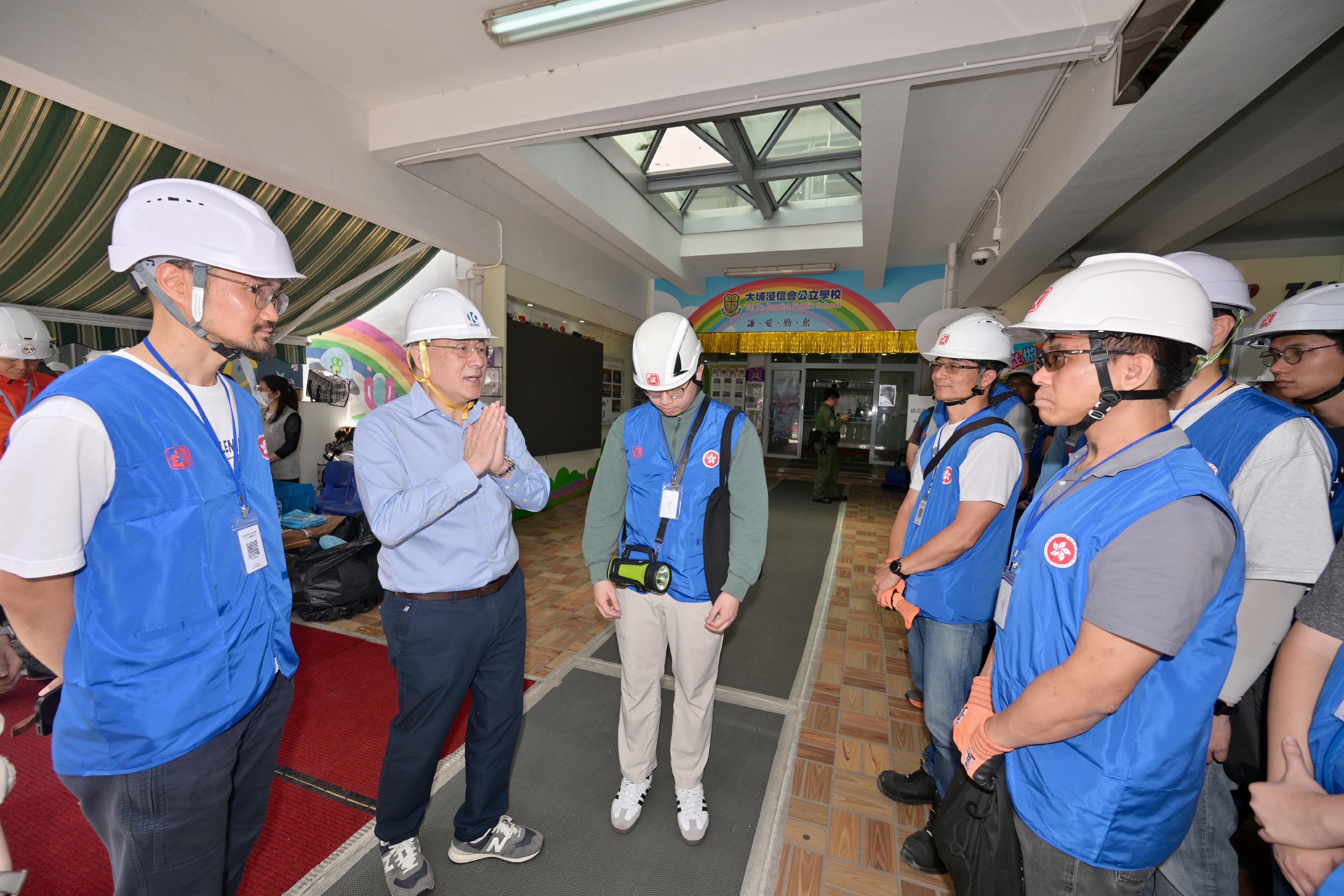 The Deputy Chief Secretary for Administration, Mr Cheuk Wing-hing, today (April 25) inspected the arrangements for residents of Wang Fuk Court in Tai Po returning to their units. Photo shows Mr Cheuk (second left) talking with civil servants mobilised from the Electrical and Mechanical Services Department.